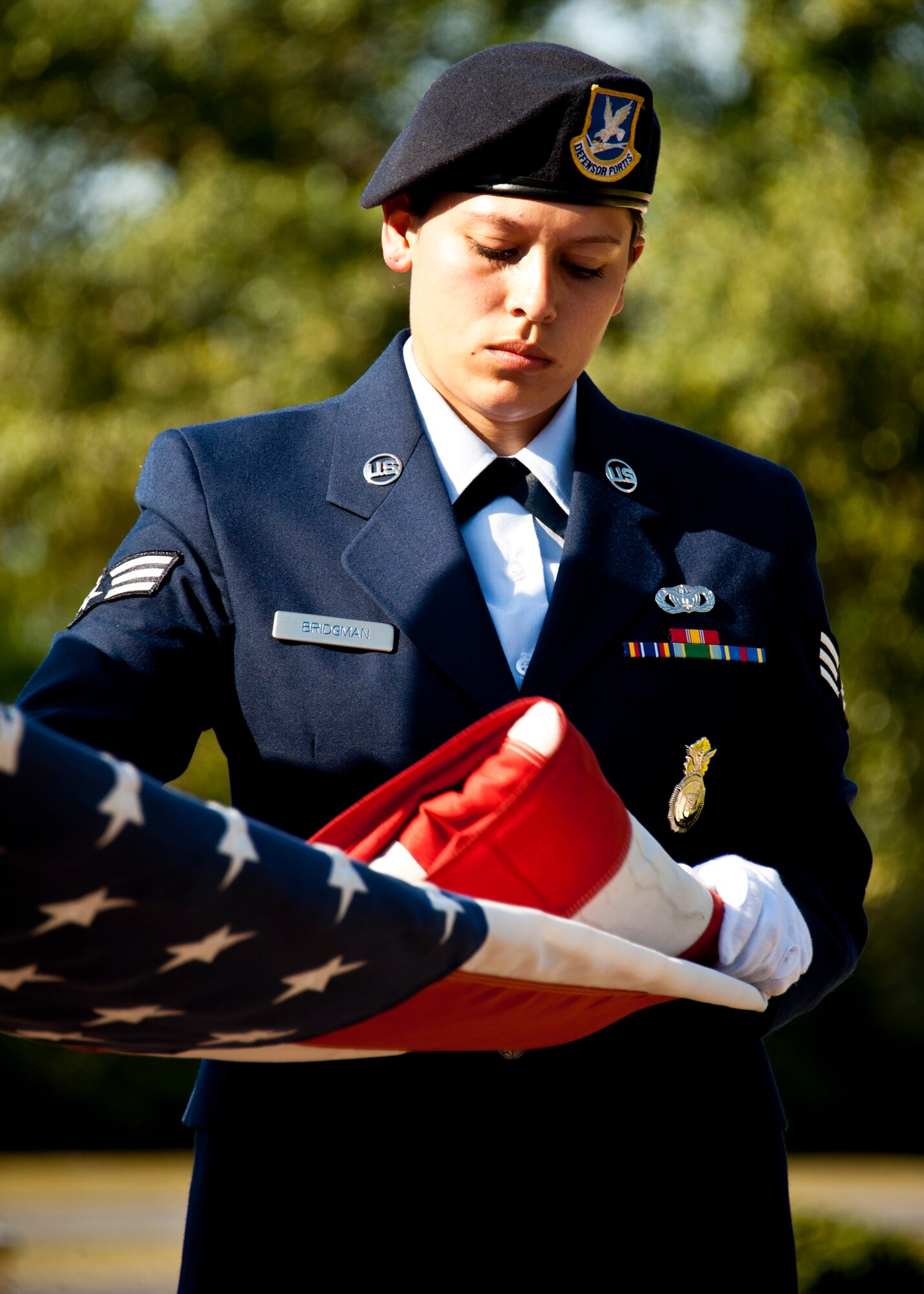 Senior Airman Tiffany Bridgman, 96th Security Forces Squadron, folds the flag up during a Retreat ceremony at Eglin’s All Wars Memorial May 20.  The ceremony closed out a week of activities by base security forces and local law enforcement in celebration of National Police Week.  (U.S. Air Force photo/Samuel King Jr.)