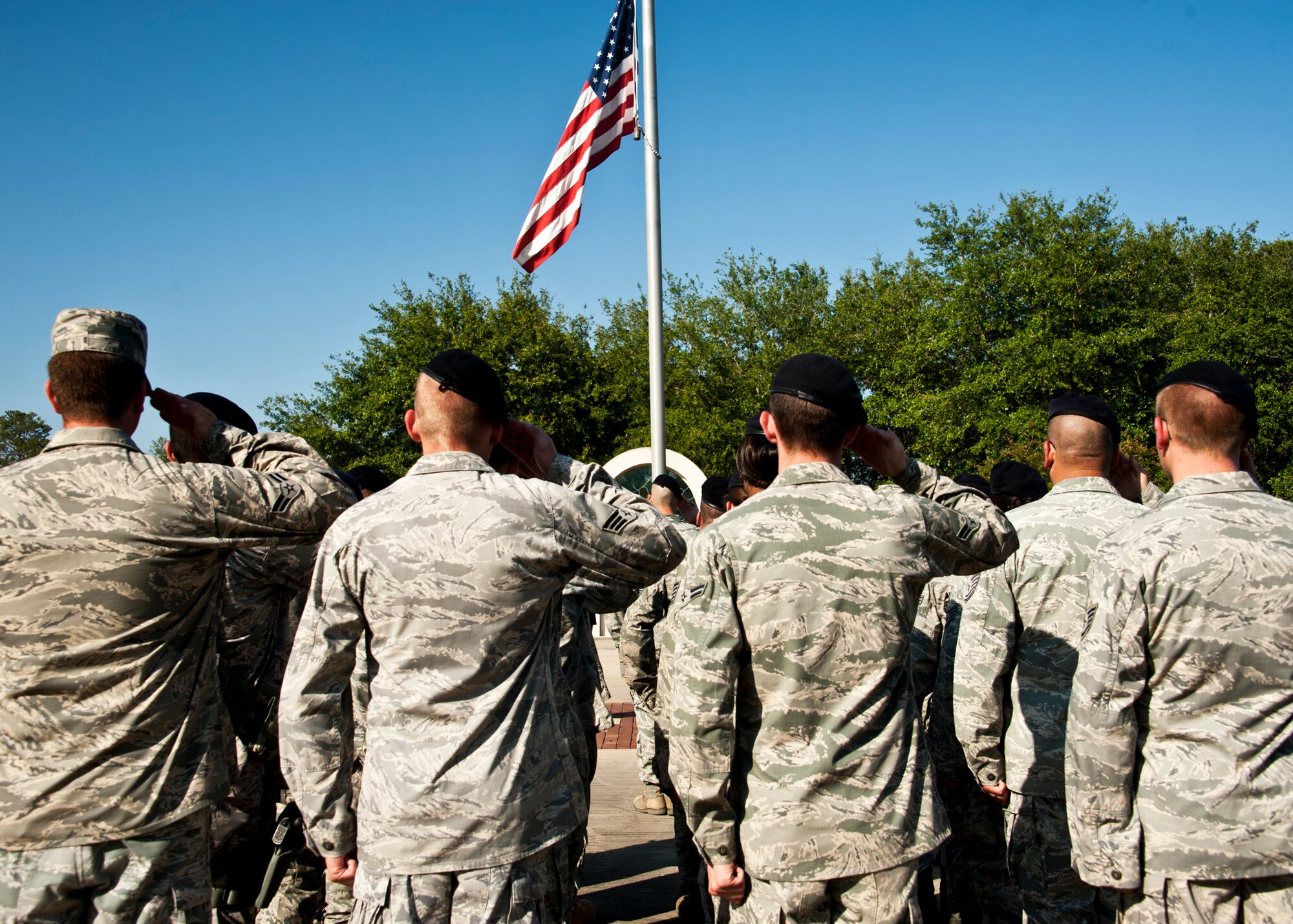 A flight of 96th Security Forces Squadron Airmen salute the flag as it descends during a Retreat ceremony at Eglin’s All Wars Memorial May 20.  The ceremony closed out a week of activities by base security forces and local law enforcement in celebration of National Police Week.  (U.S. Air Force photo/Samuel King Jr.)