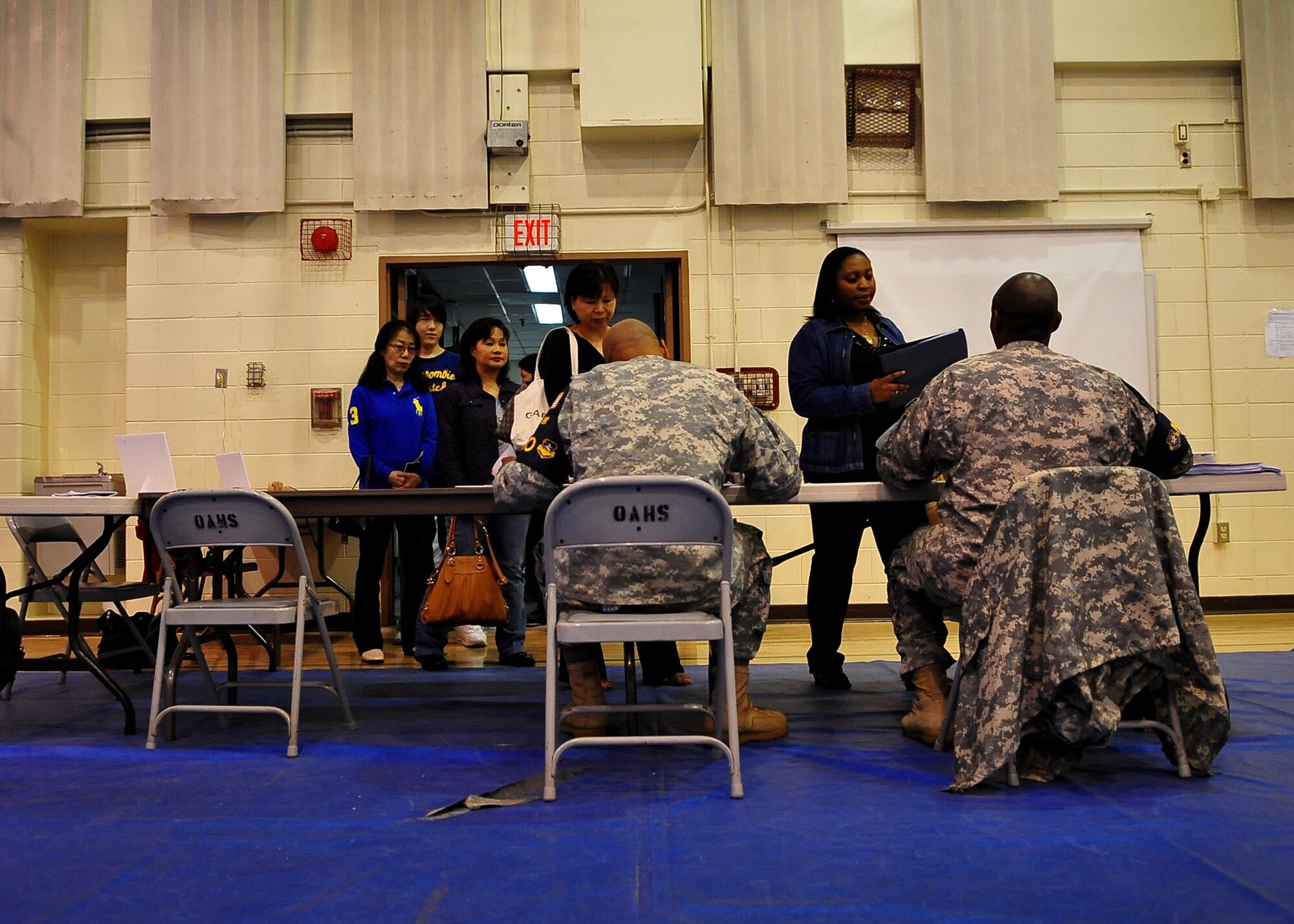 U.S. military dependents, non-emergency essential civilians and contractors walk through a processing line at Osan American High School.  These individuals are participating in the Courageous Channel exersice which is held every spring to train servicemembers on registration and evacuation processes. (U.S. Air Force photo/Senior Airman Evelyn Chavez)