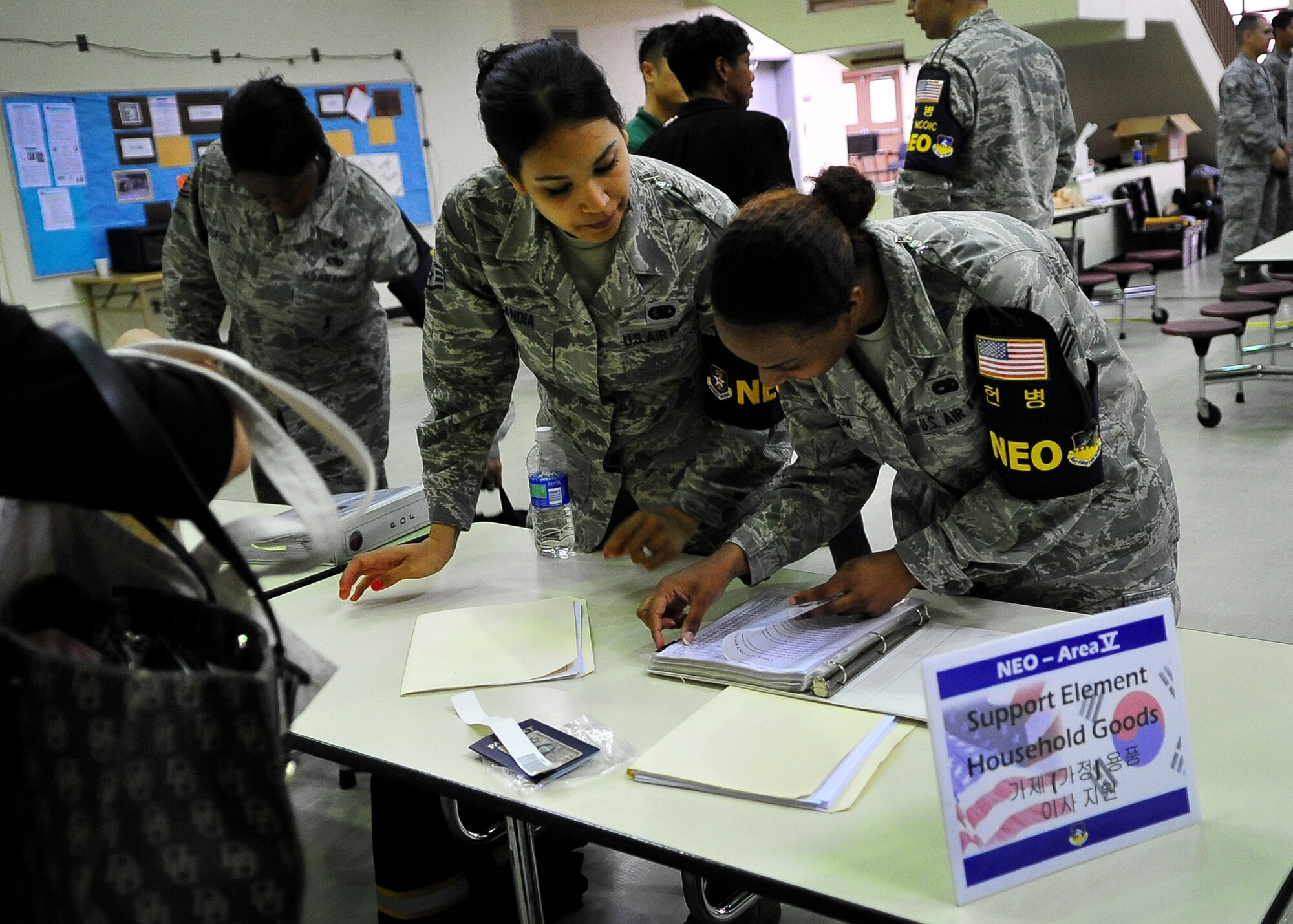 Staff Sgt. Vanessa Candia and Senior Airman Jennika Walton, 51st Logistics Readiness Squadron help process dependents, non-emergency essential civilians and contractors May 20. Individuals are participating in the Courageous Channel exersice which is held every spring to train service members on registration and evacuation processes. (U.S. Air Force photo/Senior Airman Evelyn Chavez)