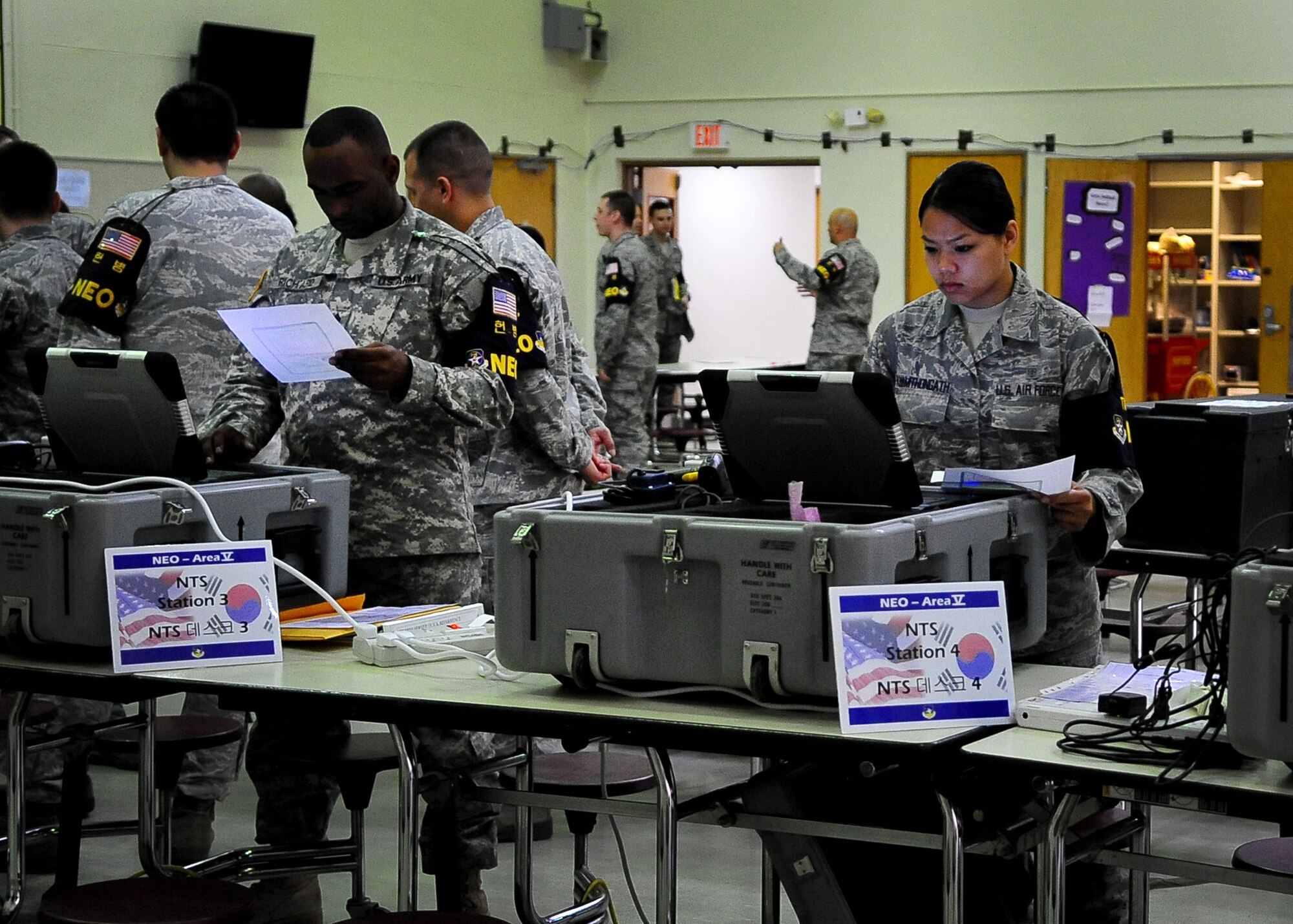 U.S. Army and Air Force personnel prepare to process dependents, non-emergency essential civilians and contractors May 20. Individuals are participating in the Courageous Channel exersice which is held every spring to train servicemembers on registration and evacuation processes. (U.S. Air Force photo/Senior Airman Evelyn Chavez)