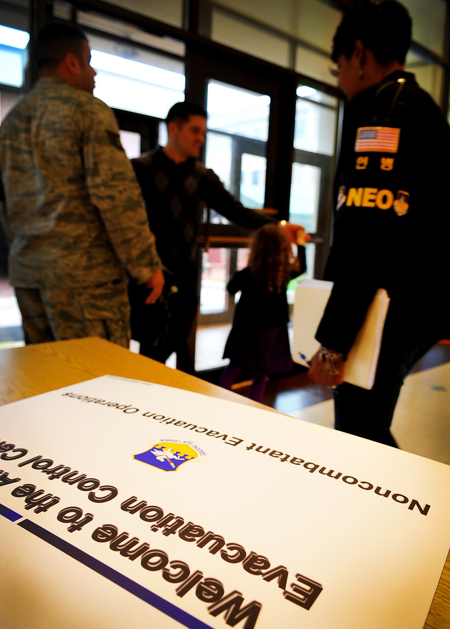U.S. military dependents, non-emergency essential civilians and contractors walk through a processing line at Osan American High School.  These individuals are participating in the Courageous Channel exersice which is held every spring to train servicemembers on registration and evacuation processes. (U.S. Air Force photo/Senior Airman Evelyn Chavez)