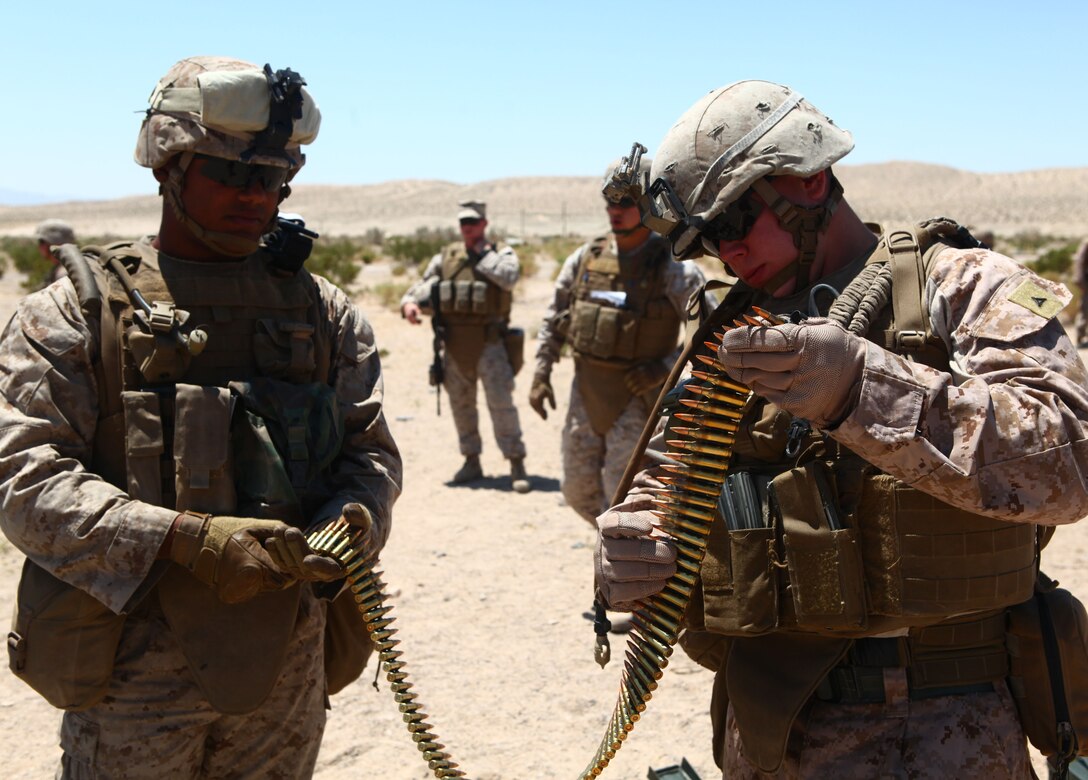 Lance Cpl. Brandon Baia (right), a squad leader with Weapons platoon, Company B, 1st Battalion, 6th Marine Regiment, 2nd Marine Division, divvies out ammunition for his Marines during a machine-gun range at Marine Corps Base 29 Palms, Calif., May 23, 2011.  The Marines and sailors of 1/6 are taking part in the Enhanced Mojave Viper exercise, a large-scale predeployment training event aimed at preparing the battalion for their upcoming deployment to Afghanistan.