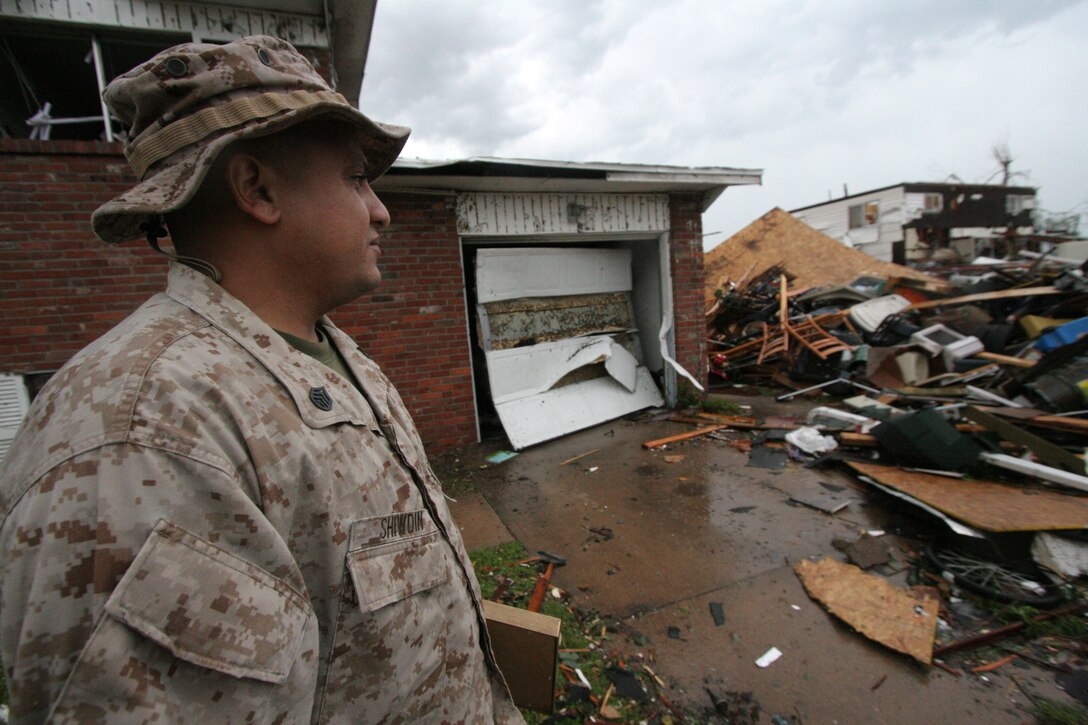 Staff Sgt. Neville Shiwdin looks over his family's home in Joplin, Mo. May 23 after it's destruction by a tornado the night before. During the tornado, Shiwdin struggled to keep the door closed on their home's closet where he, his wife and kids took shelter. Shiwdin is a recruiter at Recruiting Sub Station Joplin, Recruiting Station Kansas City.