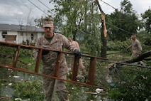 Maj. Thomas McGee finds a ladder among debris so that he and others can begin patching one of his Marine's roof May 23 after it was damaged by a tornado that ripped through Joplin the night before. McGee is the commanding officer of Recruiting Station Kansas City.