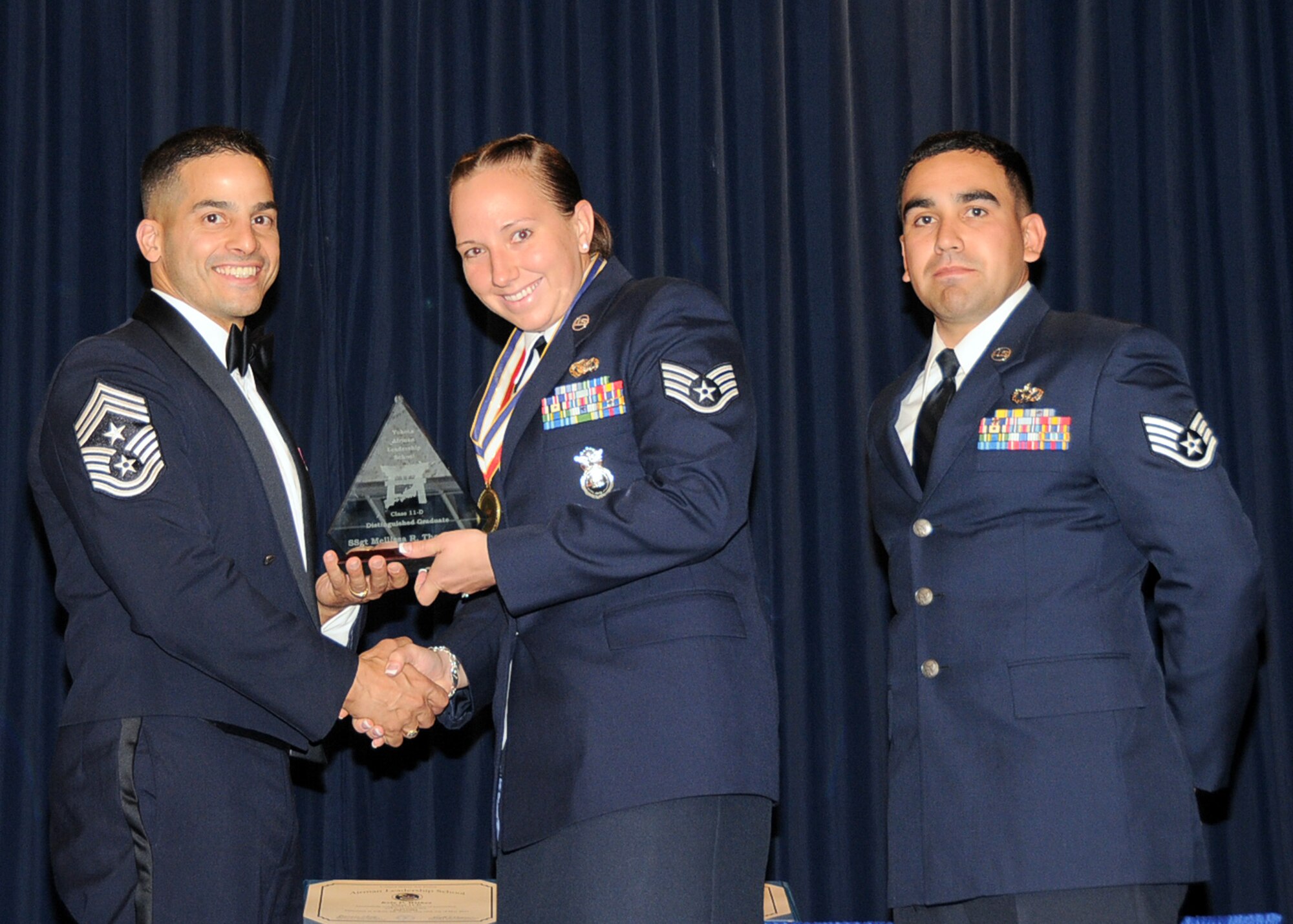 YOKOTA AIR BASE, Japan -- Staff Sgt. Melissa Thompson, 374th Security Forces Squadron, receives the Distinguished Graduate Award, from Chief Master Sgt. Benjamin Caro, 374th Airlift Wing command chief, during the Airman Leadership School graduation ceremony at Yokota Air Base, Japan, May 19, 2011. (U.S. Air Force photo/Senior Airman Andrea Salazar)