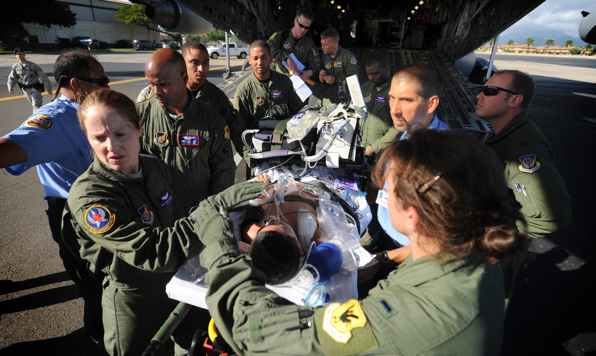 Members from the 18th Aeromedical Evacuation Squadron and 13th Air Force Surgeon Generals office transport a critically ill patient from American Samoa out of the rear of a C-17 on the Hickam Field fligthline May 22. The patient was aeromedically evacuated from Lyndon B. Johnson Tropical Medical Center in Pago Pago, American Samoa after he aspirated following a seizure that left him completely reliant on a ventilator to breathe. The patient was transfered to Tripler Army Medical Center, Hawaii.  (U.S. Air Force photo/Senior Airman Lauren Main)