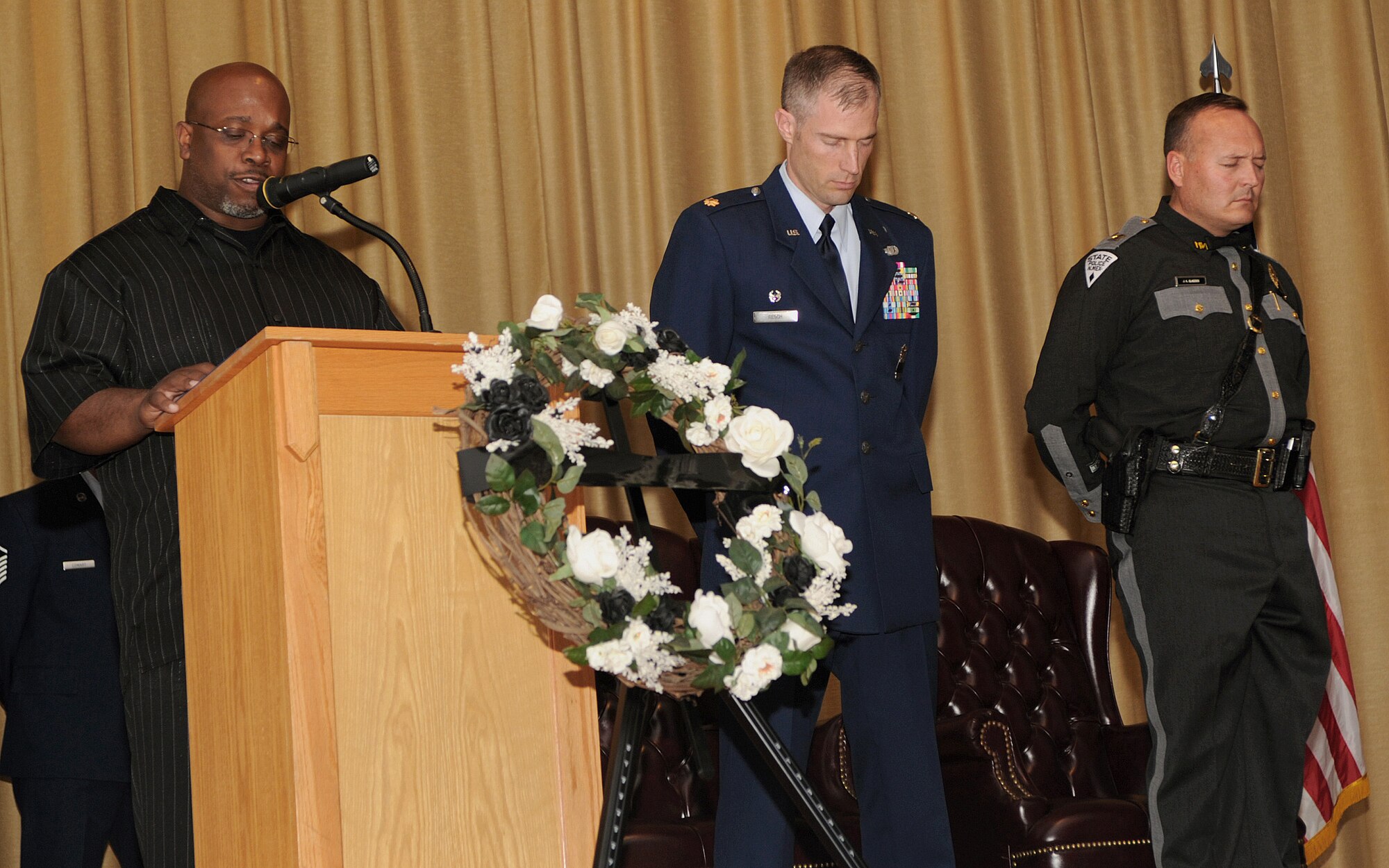 James Russell, 27th Special Operations Security Forces Squadron, leads prayer beside U.S. Air Force Maj. Andrew Resch, 27th SOSFS commander, and Capt. Jimmy Glascock, State Police District Nine commander, at Cannon Air Force Base, N.M., May 20, 2011.  Police Week ended with a retreat ceremony including a reading of the names of fallen policemen and women.  (U.S. Air Force photo by Senior Airman James Bell) 