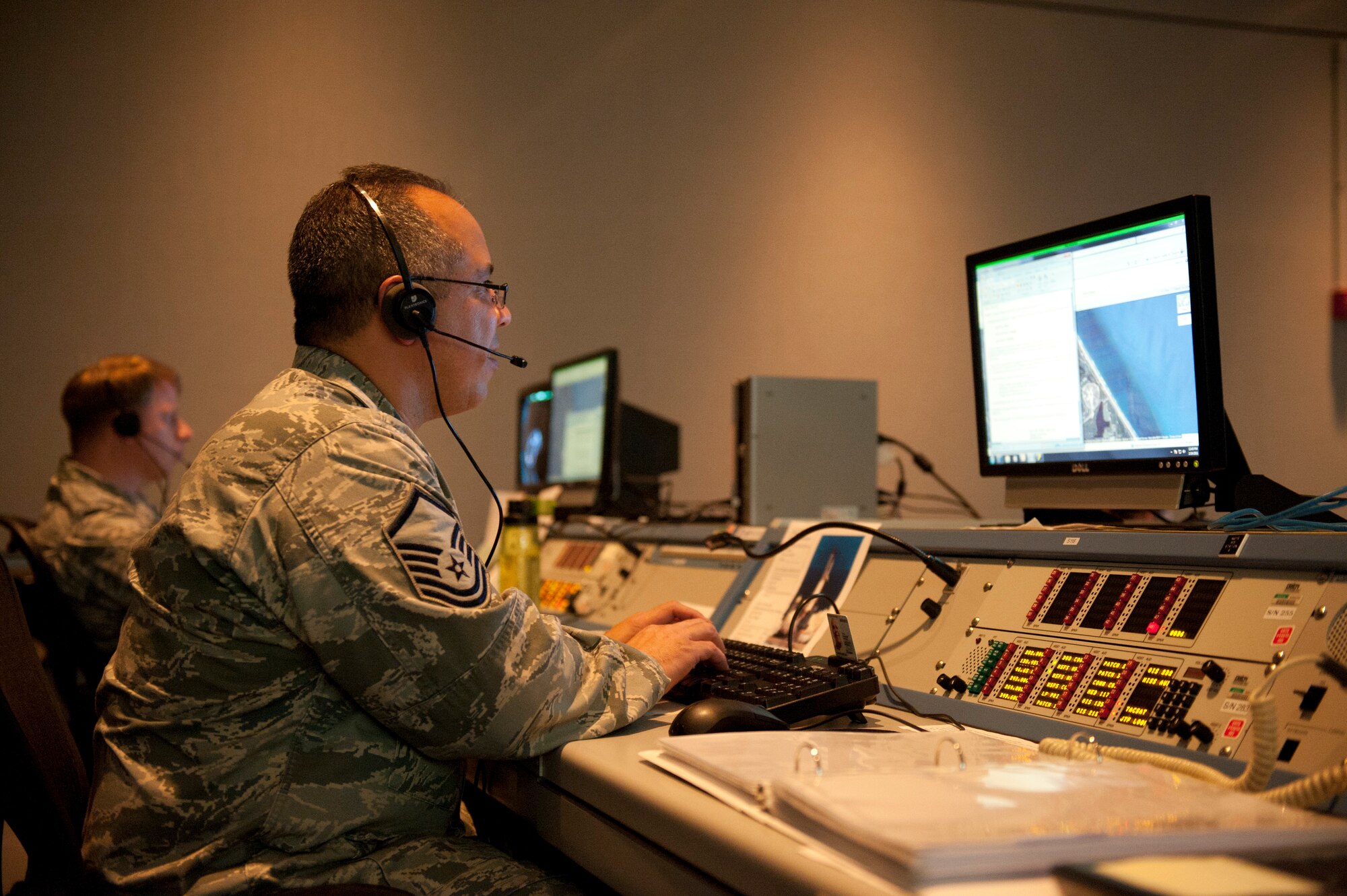 Master Sgt. Jose Torres, a cyber systems manager on the Joint Task Force - Space Transportation System team, works with Maj. Normand Burroughs, team director of communications, to ensure all computer requirements are met prior to and during the shuttle launch mission. (U.S. Air Force photo by Jonathan Gibson)