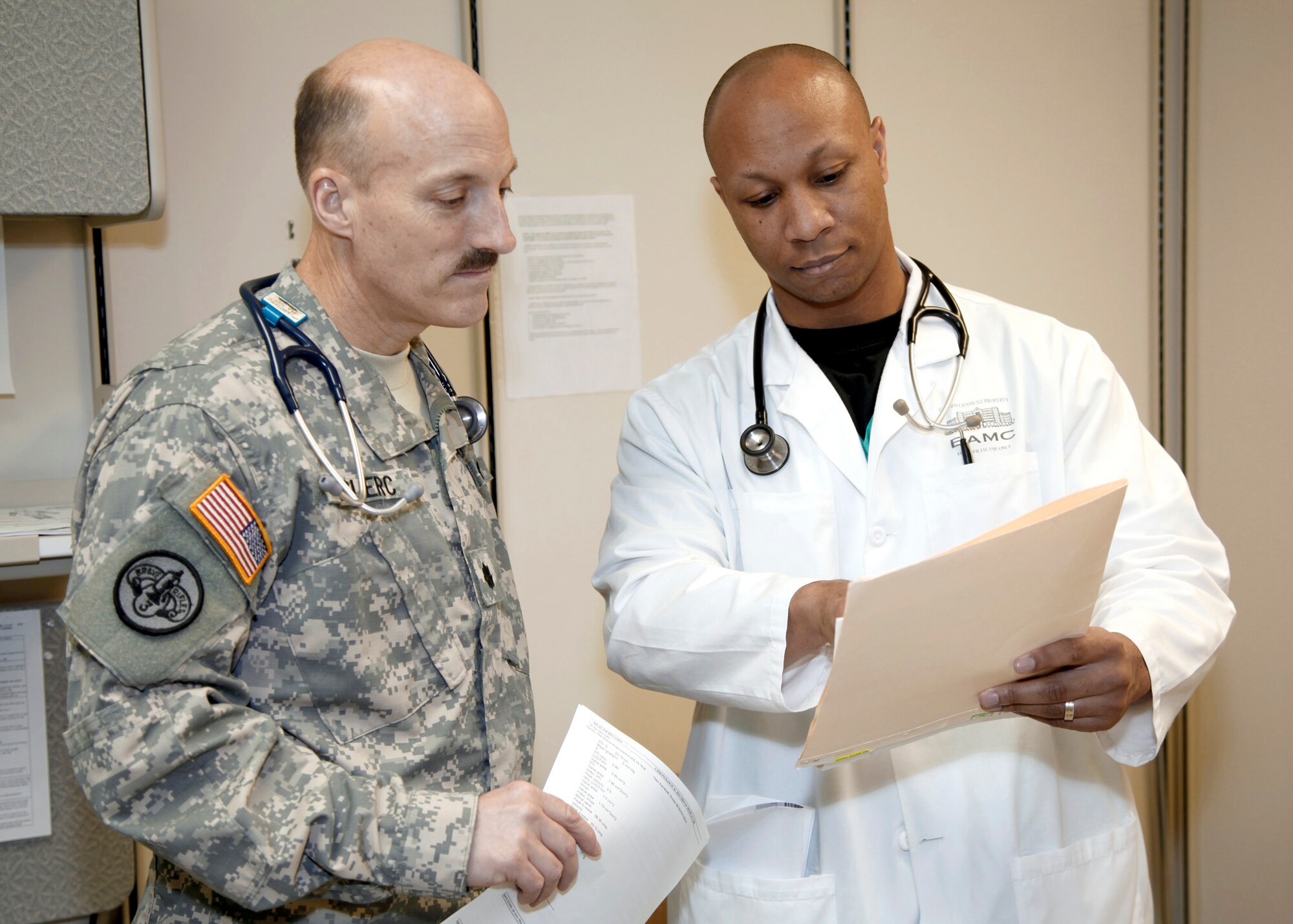 Cardiologists Air Force Maj. (Dr.) Van Adamson (right) and Army Lt. Col. (Dr.) Kenneth Leclerc review a patient's records May 20 in the Brooke Army Medical Center Cardiology Clinic at Ft. Sam Houston, Texas. Dr. Adamson received a scholarship to Morehouse College, Atlanta, Ga., in 1998 through the Oprah Winfrey Endowed Scholarship program. He was interviewed about the scholarship for one of the final Oprah Winfrey television shows. (U.S. Army photo/Dwayne Snader)