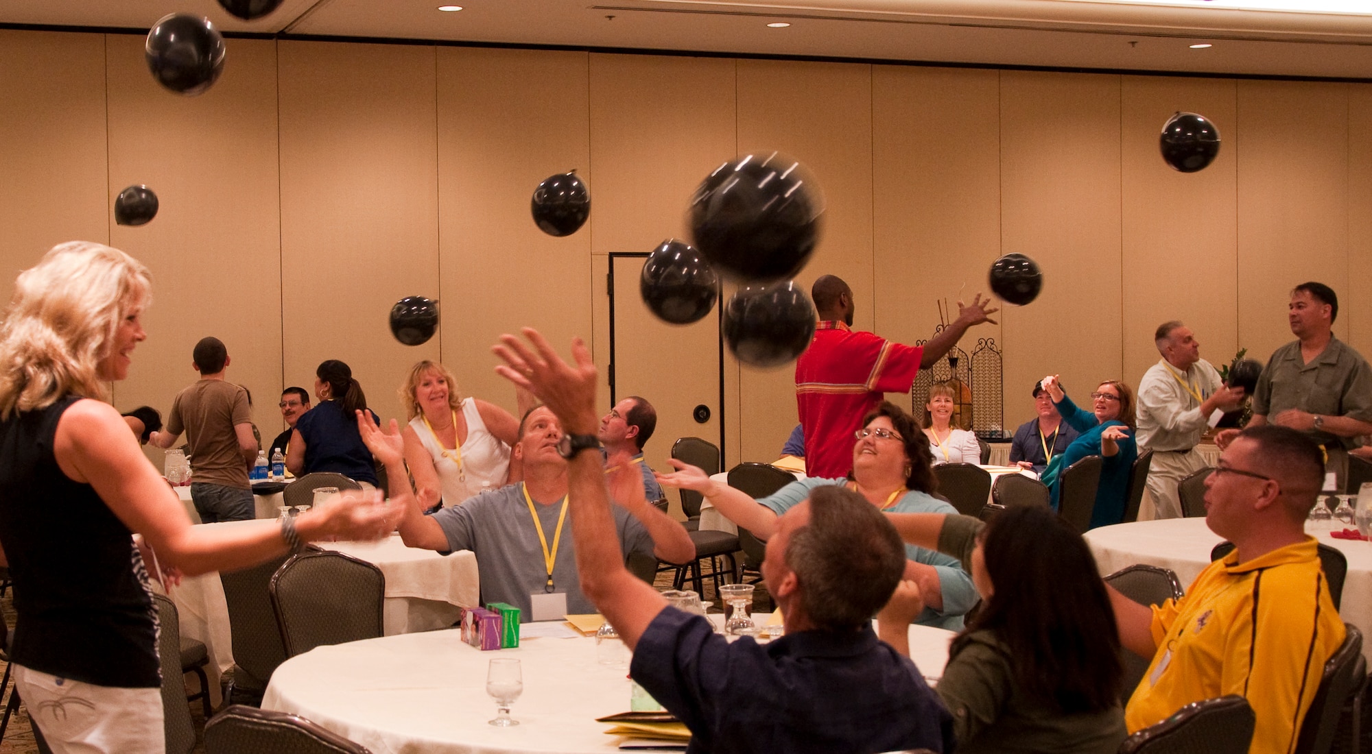 Attendees at the western regional Yellow Ribbon Event work together to keep a room full of balloons in the air during a game at the end of the event. The event, May 14-15 at the Tempe Mission Palms Resort in Tempe, Ariz., was designed to help prepare Reservists, Guardsmen and their families for upcoming deployments, as well as to welcome those who had recently returned home. (U.S. Air Force Photo/Staff Sgt. Erin Smith)