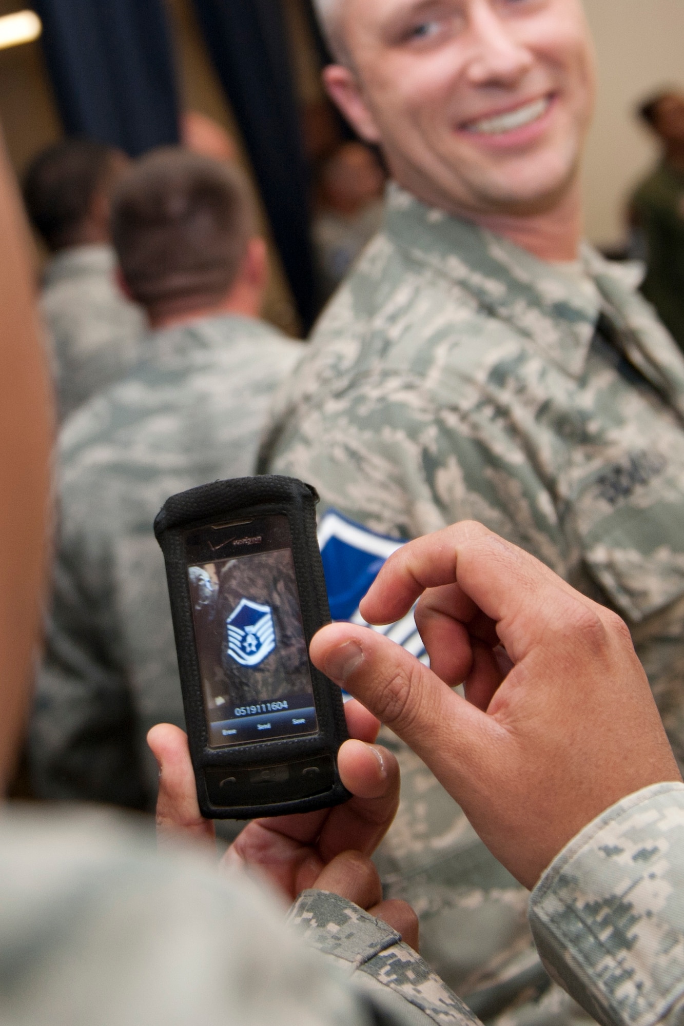 HOLLOMAN AIR FORCE BASE, N.M. -- Tech. Sgt. Marco Mata takes a photo of Tech. Sgt. Brian Douglas’ pending master sergeant stripes May 19, 2011, at the Master Sergeant Promotion Party in the Enlisted Club’s Desert Sands Ballroom. Sergeants Mata and Douglas were two of 68 Holloman technical sergeants selected for promotion to master sergeant. Air Force officials selected 6,618 of 19,538 eligible technical sergeants for promotion to master sergeant for a selection rate of 33.87 percent. (U.S. Air Force photo by Senior Airman Veronica Stamps/Released)