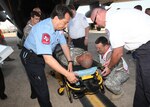 Emergency responders from Joint Base San Antonio, Southwest Texas Regional Advisory Council on Trauma and American Medical Response prepare a patient for transport during the National Disaster Medical System exercise at Kelly Field May 17.(U.S. Air Force photo/Robbin Cresswell)