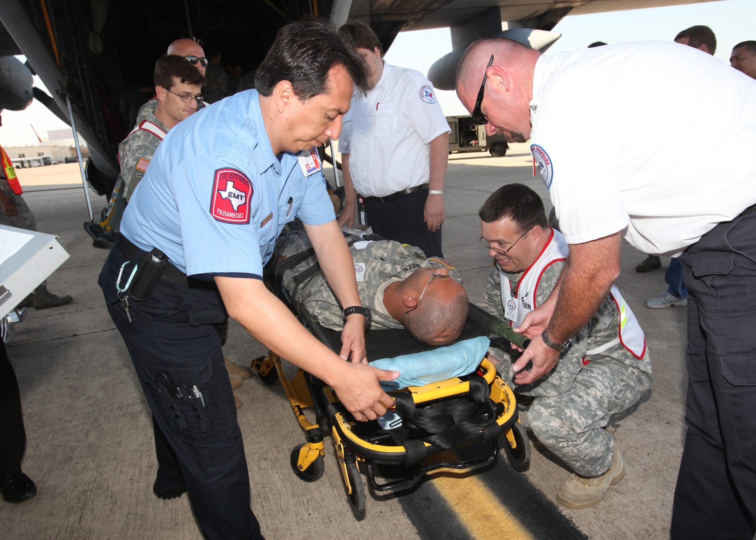 Emergency responders from Joint Base San Antonio, Southwest Texas Regional Advisory Council on Trauma and American Medical Response prepare a patient for transport during the National Disaster Medical System exercise at Kelly Field May 17.(U.S. Air Force photo/Robbin Cresswell)