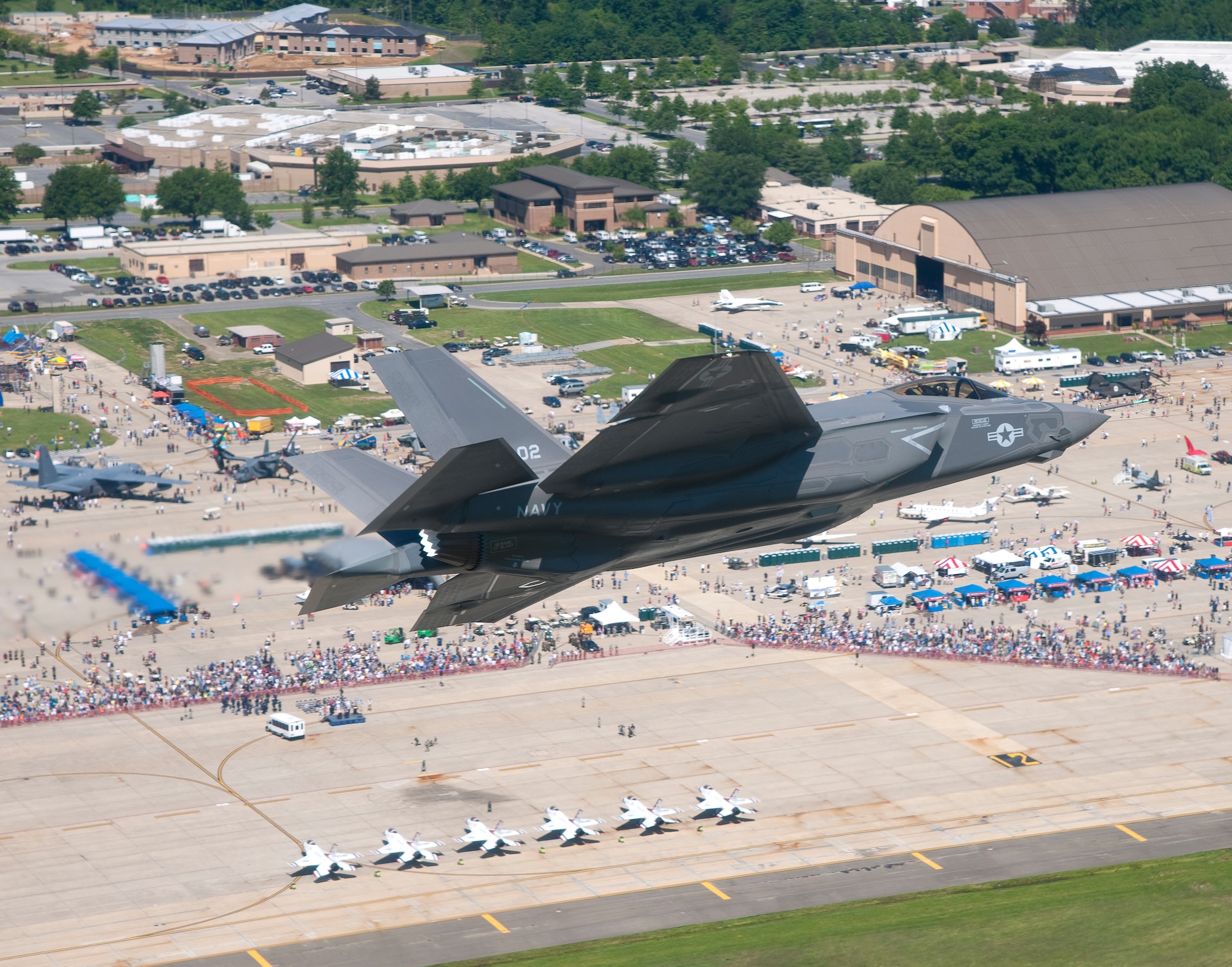 An aircraft carrier variant of the F-35C Joint Strike Fighter flies over Joint Base Andrews, Md., during the 2011 Joint Service Open House. This is the first public appearance of a joint strike fighter aircraft at an air show. Lt. Cmdr. Eric "Magic" Buus piloted the aircraft. The F-35C is a fifth generation strike fighter with stealth capability and has larger wing surfaces and reinforced landing gear for the demanding carrier environment. The aircraft is undergoing test and evaluation at Naval Air Station Patuxent River. (U.S. Navy photo by Andy Wolfe courtesy of Lockheed Martin/Released)