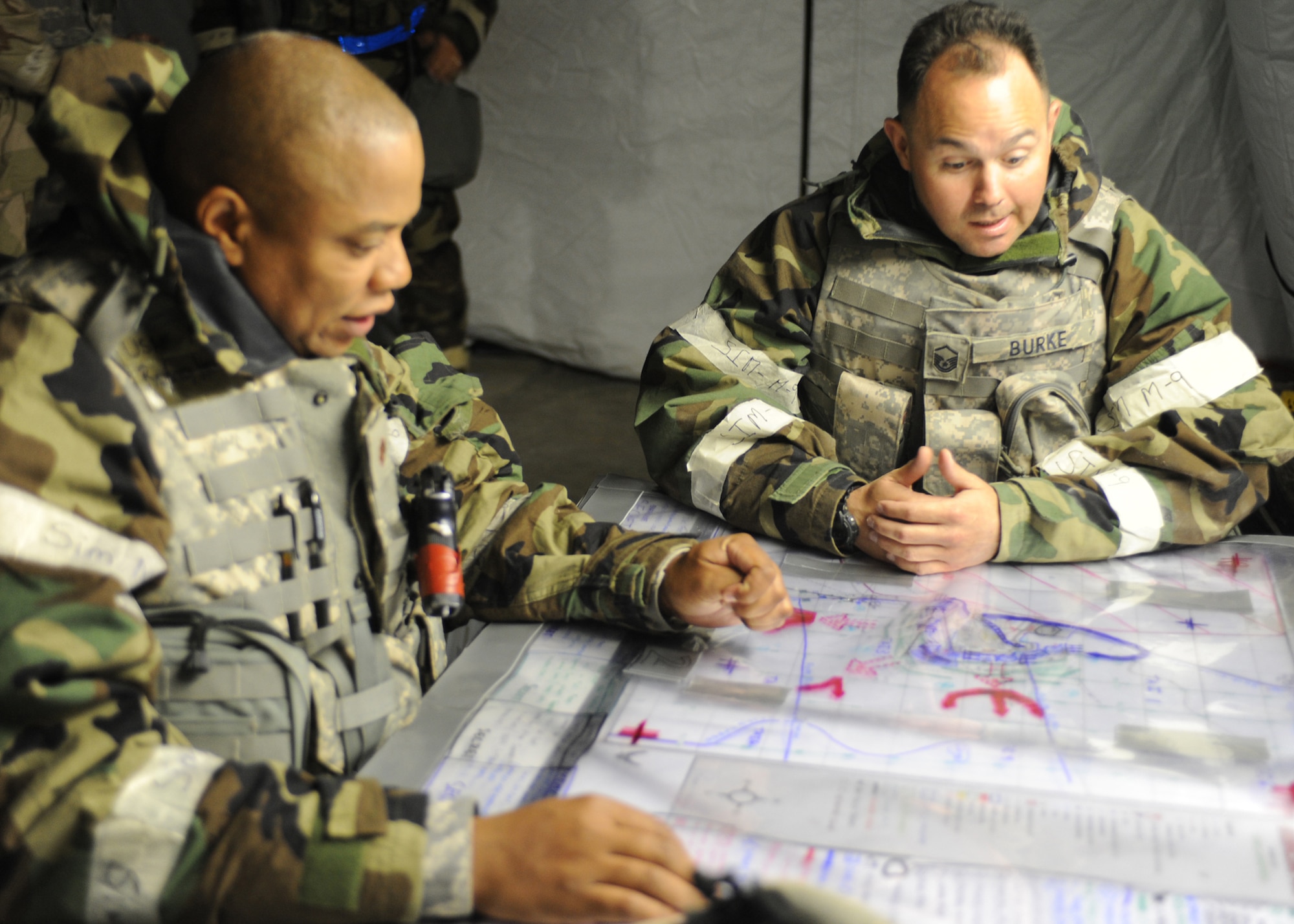 Dyess Air Force Base, Texas--Exercise..Exercise..Exercise Maj. Rodney Heard, 7th Expeditionary Security Forces defense force commander and Master Sgt. Richard Burke, 7th ESFS flight sergeant both deployed from Dyess Air Force Base, Texas, discuss base defense planning at the base defense operations center May 17 at Ray Rangel Air Base, Guam. Major Heard plans the base defense while Sergeant Burke passes on the information to defensive fighting positions, entry control points and ground forces. (U.S. Air Force photo by Airman 1st Class Jenifer H. Calhoun)