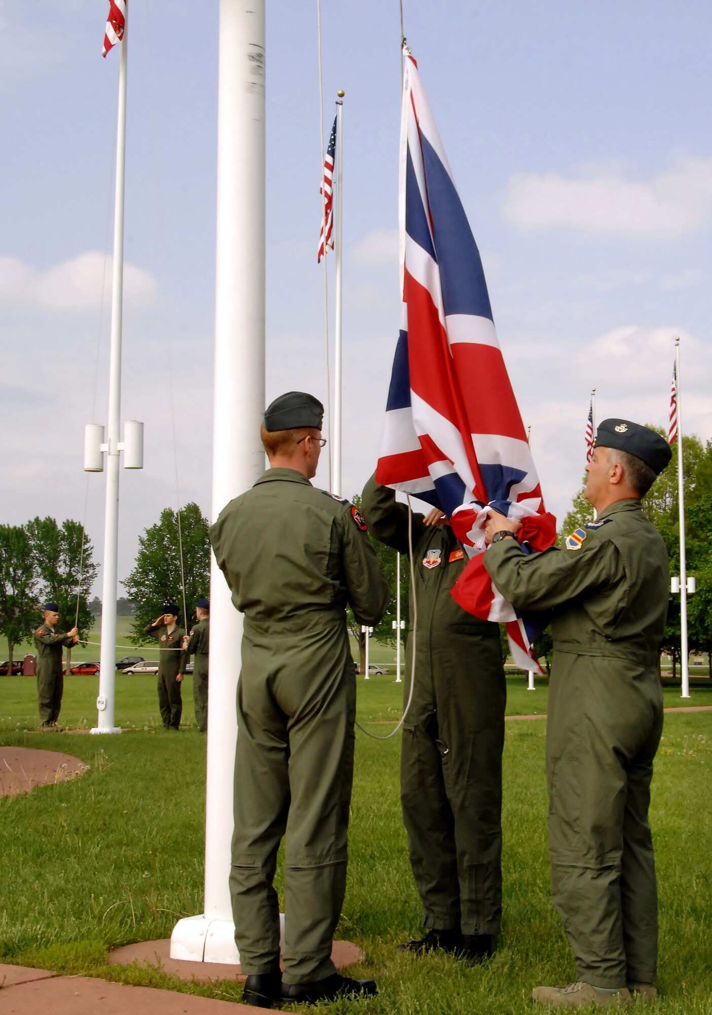 OFFUTT AIR FORCE BASE, Neb. -- The flag of the United Kingdom is lowered by Royal Air Force members Master Aircrew Kevin Ross, Master Aircrew Glyn Vigurs and Master Aircrew Stephen Jones during a special retreat ceremony here May 18. The RAF members are attending RC-135V/W initial qualification training here and joined with other members of the 338th Combat Training Squadron in the special ceremony at the parade grounds. (Air Force photo by Dana Heard)