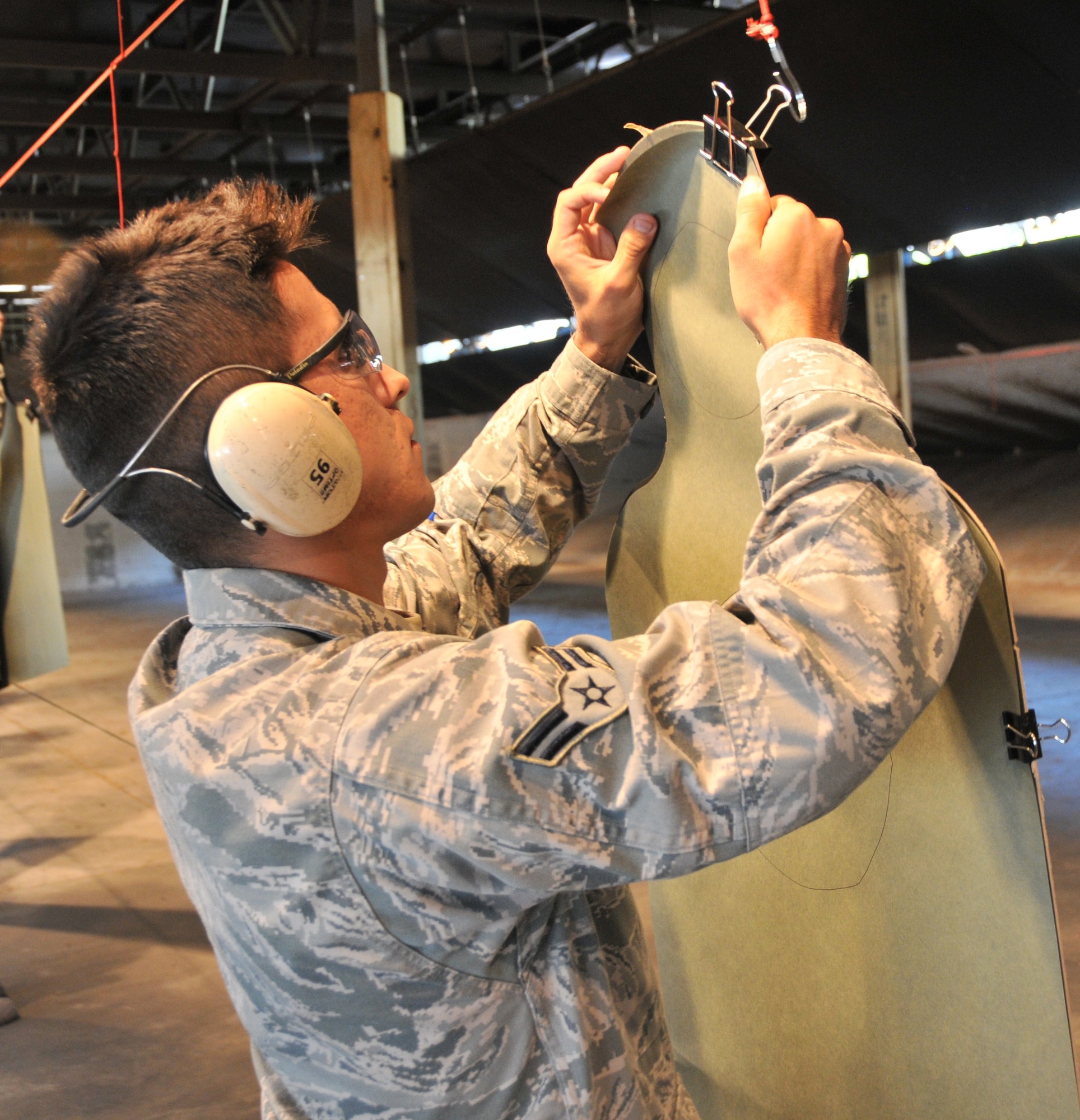 Airman 1st Class German Cubero, a 628th Civil Engineering Squadron water and fuel maintenance system technician and a 628th Security Forces Squadron augmentee, hangs a target during an M-9 qualification training May 18, at Joint Base Charleston – Air Base. More than 25 Security Forces augmentees participated in the qualification. Special thanks to all of the men and women who took into account ‘service before self’ by volunteering to become an augmentee during a time of need. (U.S. Air Force photo /Airman 1st Class Jared Trimarchi)
