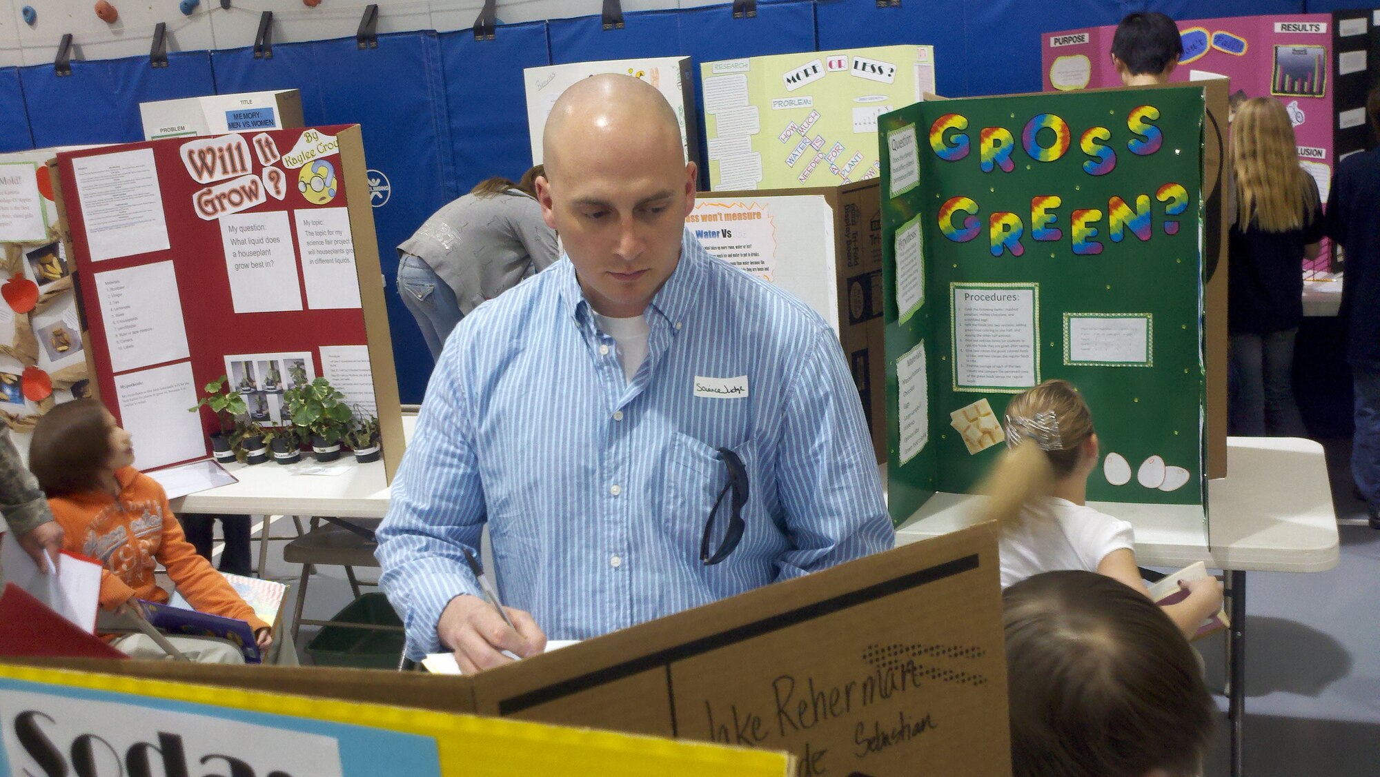 COLORADO SPRINGS, Colo. -- Tech. Sgt. Jacob Wall, 16th Space Control Squadron, helps judge a science fair May 17-18, 2011, at Woodmen Hills Elementary. Sergeant Wall, as well as other Airmen from the 21st Space Wing, volunteered to judge diverse third-, fourth- and fifth-grade science projects created by the students. (U.S. Air Force photo/Capt. Rakanem Milligan)