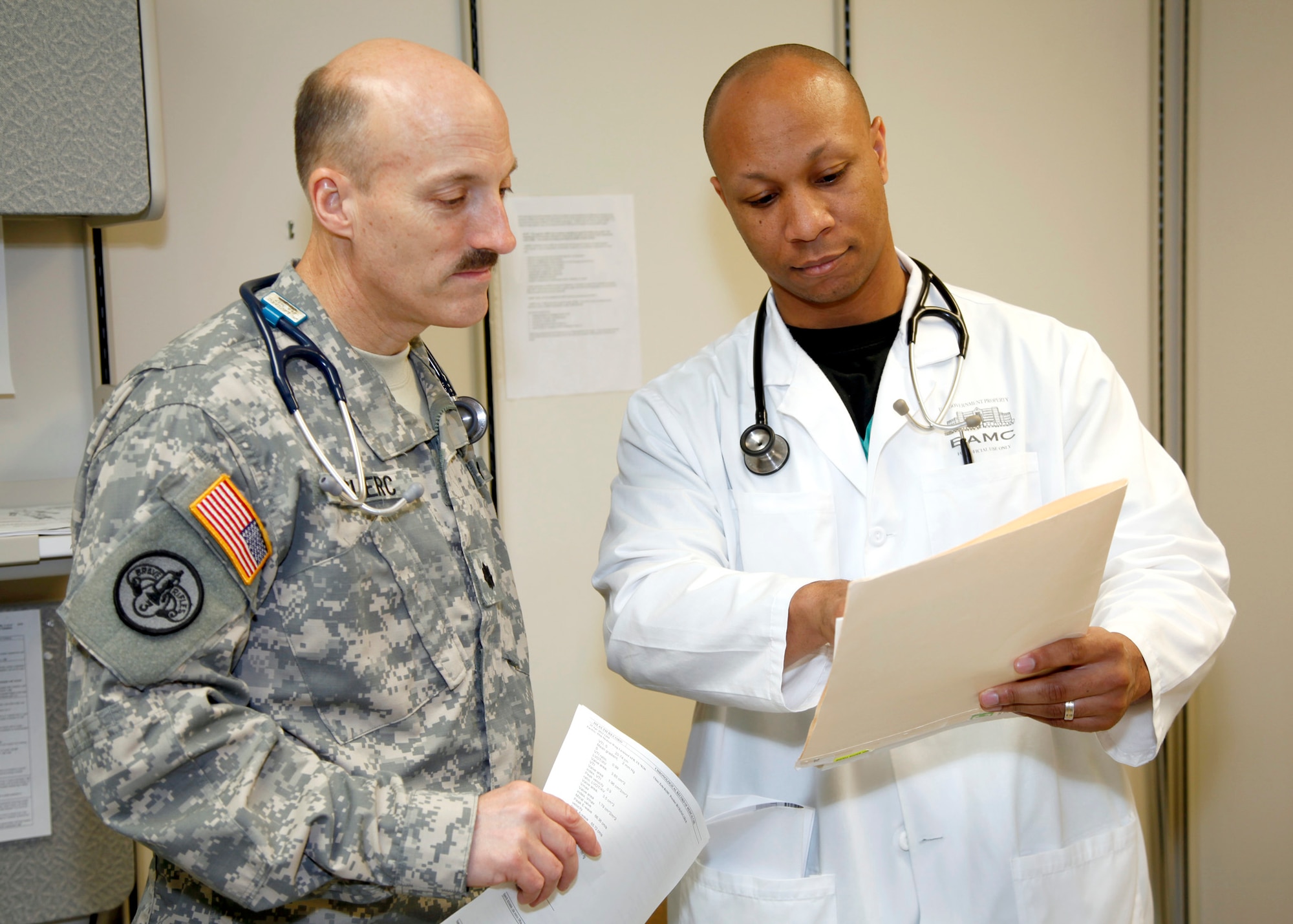 Cardiologists Air Force Maj. (Dr.) Van Adamson (right) and Army Lt. Col. (Dr.) Kenneth Leclerc review a patient's records May 20 in the Brooke Army Medical Center Cardiology Clinic, Ft. Sam Houston, Texas. Dr. Adamson received a scholarship to Morehouse College, Atlanta, Ga., in 1998 through the Oprah Winfrey Endowed Scholarship Program. He was interviewed about the scholarship for one of the final Oprah Winfrey television shows. (U.S. Army photo/Dwayne Snader)