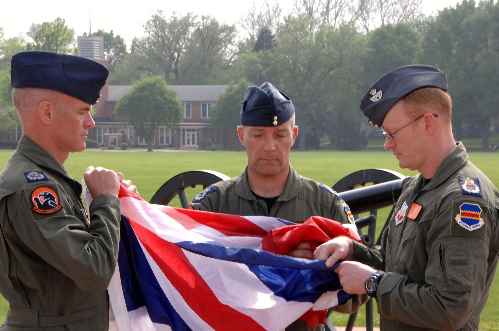 OFFUTT AIR FORCE BASE, Neb. -- The flag of the United Kingdom is folded by Royal Air Force members Master Aircrew Glyn Vigurs, Master Aircrew Stephen Jones and Master Aircrew Kevin Ross during a special retreat ceremony here May 18. The RAF members are attending RC-135V/W initial qualification training here and joined with other members of the 338th Combat Training Squadron in the special ceremony at the parade grounds. (Air Force photo by Dana Heard)