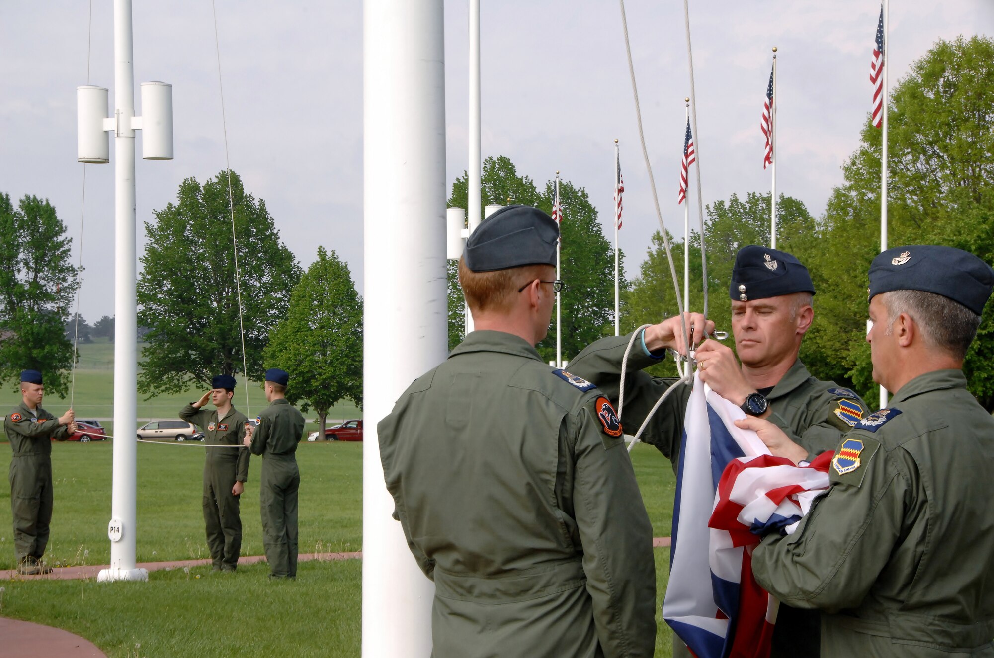 OFFUTT AIR FORCE BASE, Neb. -- The flag of the United Kingdom is taken off the flag pole by Royal Air Force members Master Aircrew Glyn Vigurs, Master Aircrew Stephen Jones and Master Aircrew Kevin Ross as three members of the U.S. Air Force lowering the American flag behind them during a special retreat ceremony here May 18. The RAF members are attending RC-135V/W initial qualification training here and joined with other members of the 338th Combat Training Squadron in the special ceremony at the parade grounds. (Air Force photo by Dana Heard)