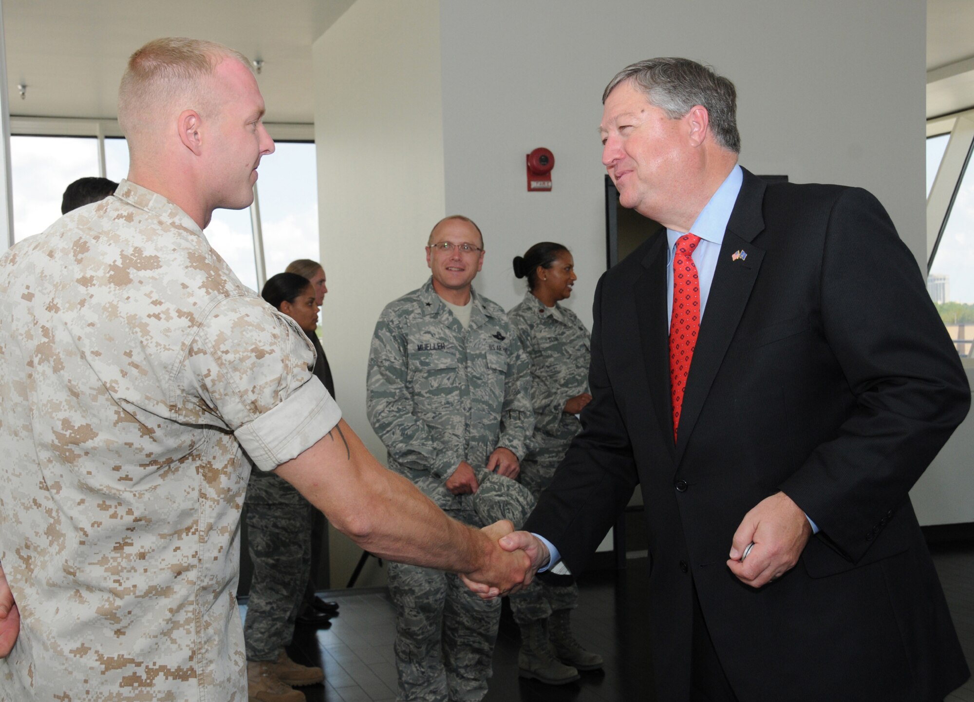 Marine Corps Master Sgt. Matthew Cline, left, a weather instructor from Keesler's Marine Corps Detachment, receives a coin from Secretary of the Air Force Michael Donley after giving a briefing on weather training in the 335th Training Squadron.  Secretary Donley and Chief Master Sgt. of the Air Force James Roy visited Keesler May 19.   (U.S. Air Force photo by Kemberly Groue)