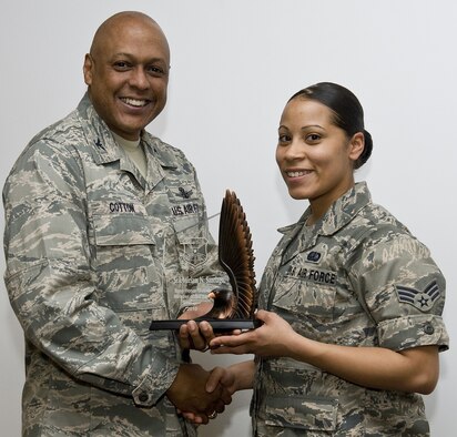 Brig. Gen. (Sel) Anthony Cotton, 341st Missile Wing commander, presents a trophy to Senior Airman Miriam Santiago, 341st Force Support Squadron, for being selected as Air Force Global Strike Command's Base Honor Guard Member of the Year. (U.S. Air Force photo/John Turner)