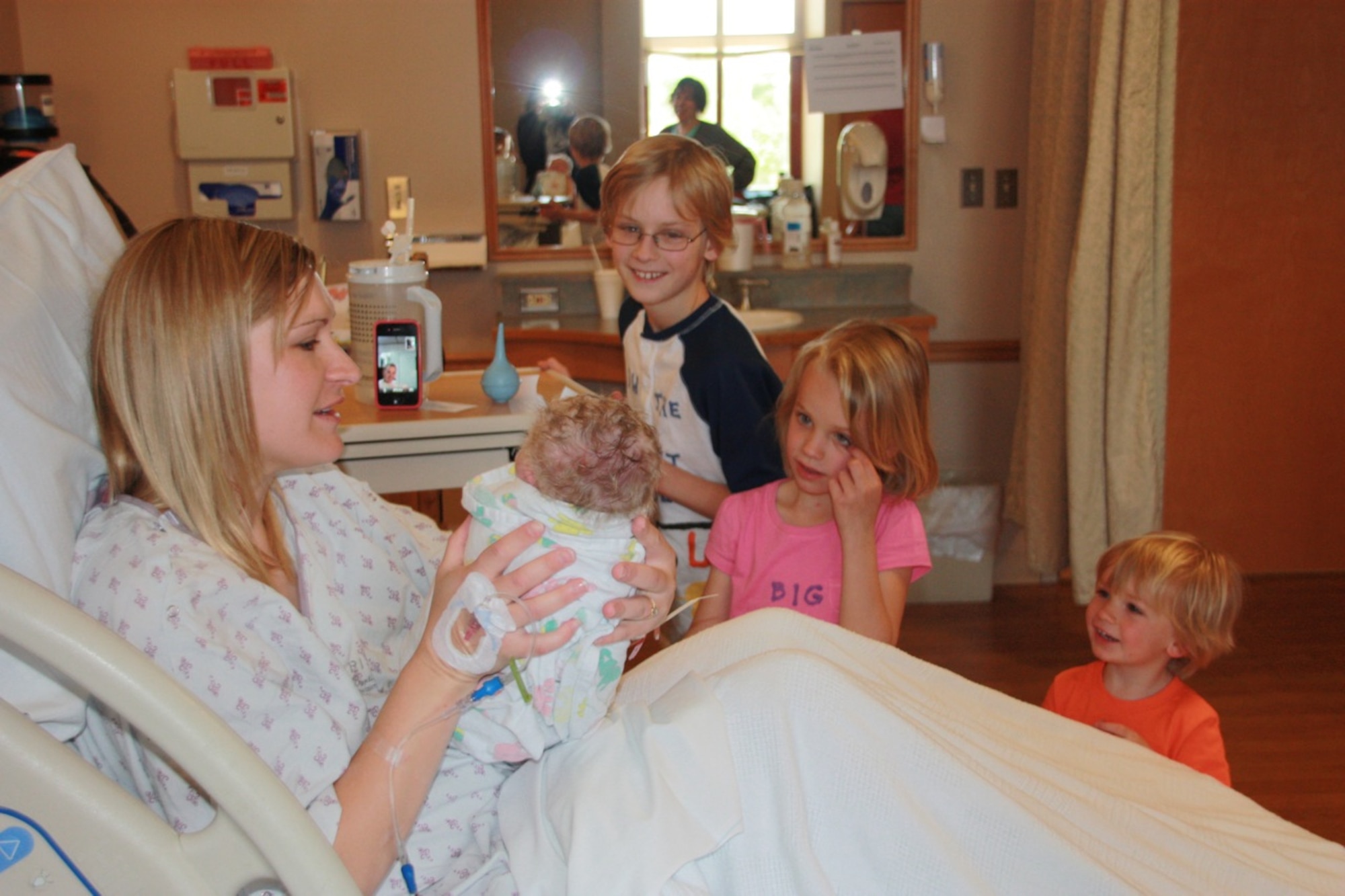 Desiree Litchfield, left, shows Cohen James Litchfield to his deployed father, 1st Lt. Arthur Litchfield, as Cohen's older siblings Ray, Annie and Kael look on May 16, 2011. Lieutenant Litchfield, deployed to Sather Air Base, Iraq, was able to watch the whole birth over the Internet. He is the Iraq Training and Advisory Mission-Air officer in charge of the foreign excess personal property program and is deployed from Hill Air Force Base, Utah.  (Courtesy photo)