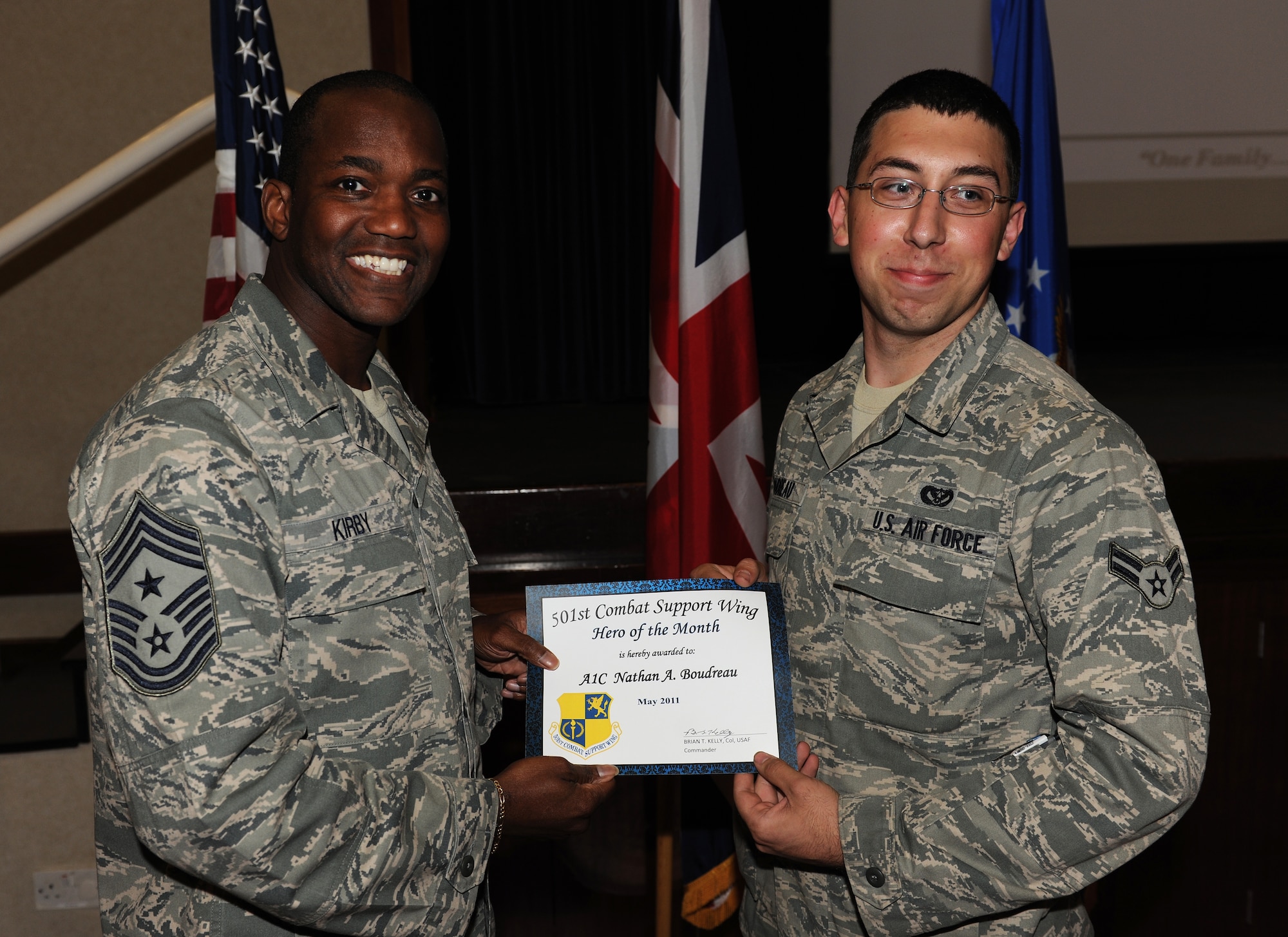 RAF Croughton, United Kingdom - Chief Master Sgt Larence Kirby, 501st Combat Support Wing Command Chief, presents Airman First Class Nathan Boudreau with Hero of the Month, 17 May 2011. (U.S. Air Force photo by Tech. Sgt. John Barton)