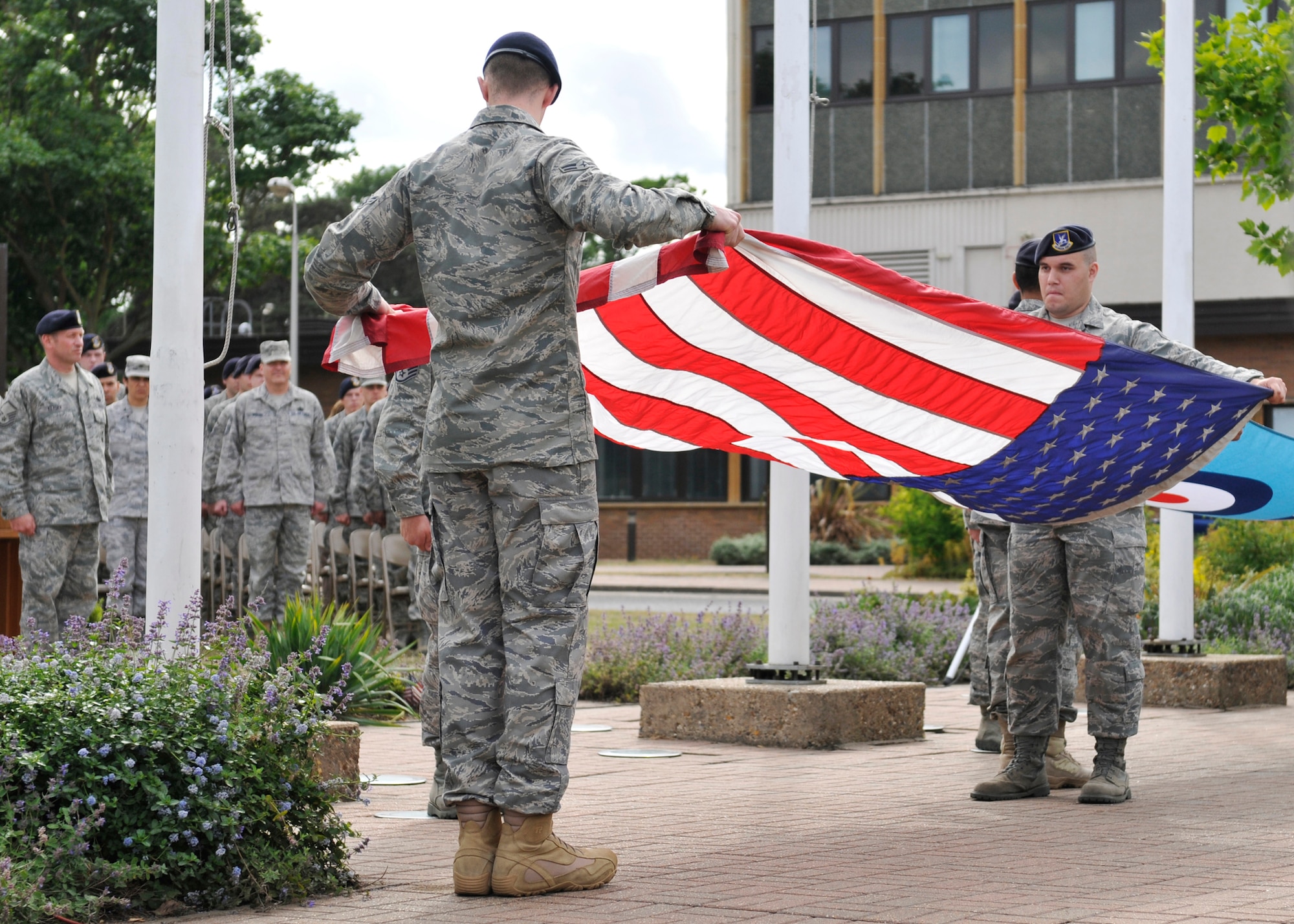 ROYAL AIR FORCE LAKENHEATH, England - Airmen from the 48th Security Forces Squadron fold the American and British flags during the Memorial and Retreat Ceremony marking the end of National Police Week at the base flag poles on May 20, 2011. National Police week honors law enforcement officers world-wide for their dedication, sacrifice and service. (U.S. Air Force photo/Senior Airman Tiffany M. Deuel)