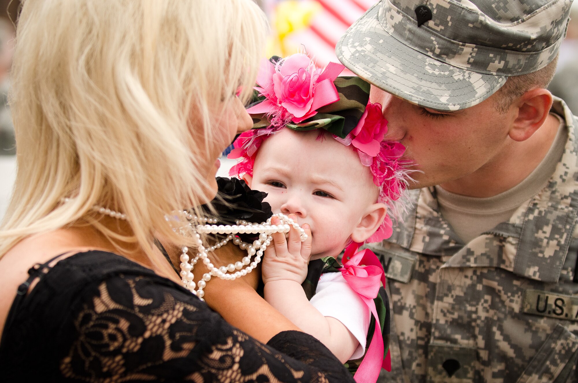 Spc. Justin H. Allen and his wife, Laura, hold their 9-month-old daughter, Elissa Skye, at the Kentucky Air National Guard Base in Louisville, Ky., during a welcome home ceremony May 1, 2011, for members of the Kentucky National Guard's Agribusiness Development Team II. Comprised of about 60 Army and Air National Guardsmen, KYADT II just returned from a 12-month deployment to Afghanistan, where they worked to make Afghani farmers become agriculturally self-sufficient, fostered business opportunities through a women's-empowerment initiative and provided force protection. Elissa Skye was born during Allen's deployment. (U.S. Air Force Photo by Maj. Dale Greer)
