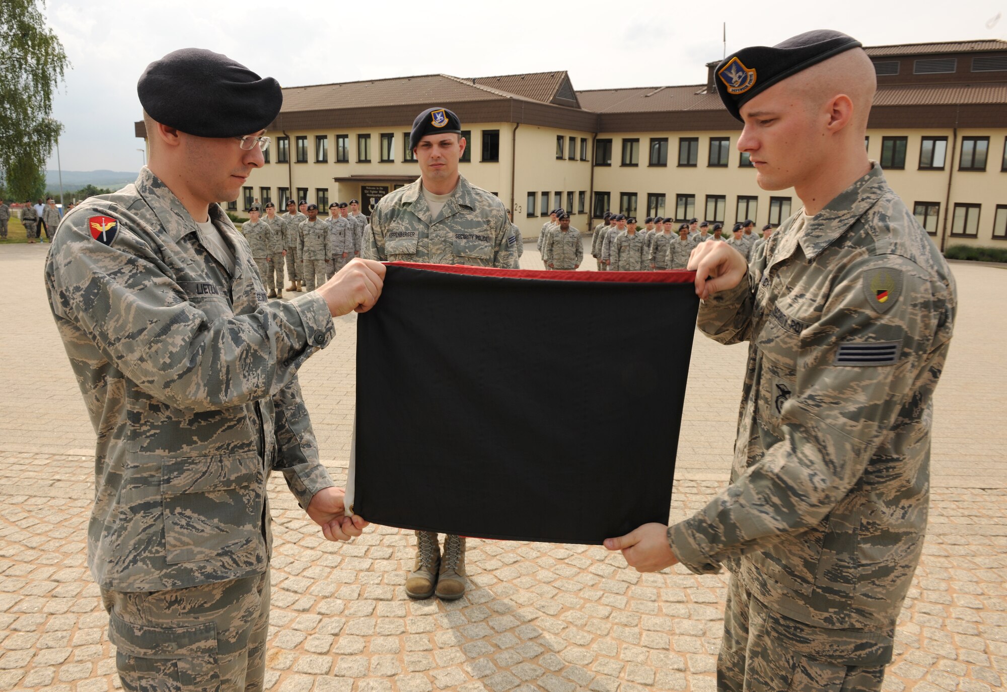 SPANGDAHLEM AIR BASE, Germany – German security police officers from the 52nd Security Forces Squadron fold the German flag during a retreat ceremony here May 20. The retreat ceremony coincided with National Police Week, which honors law enforcement members who have lost their lives in the line of duty for the safety and protection of others. (U.S. Air Force photo/Senior Airman Nathanael Callon)
