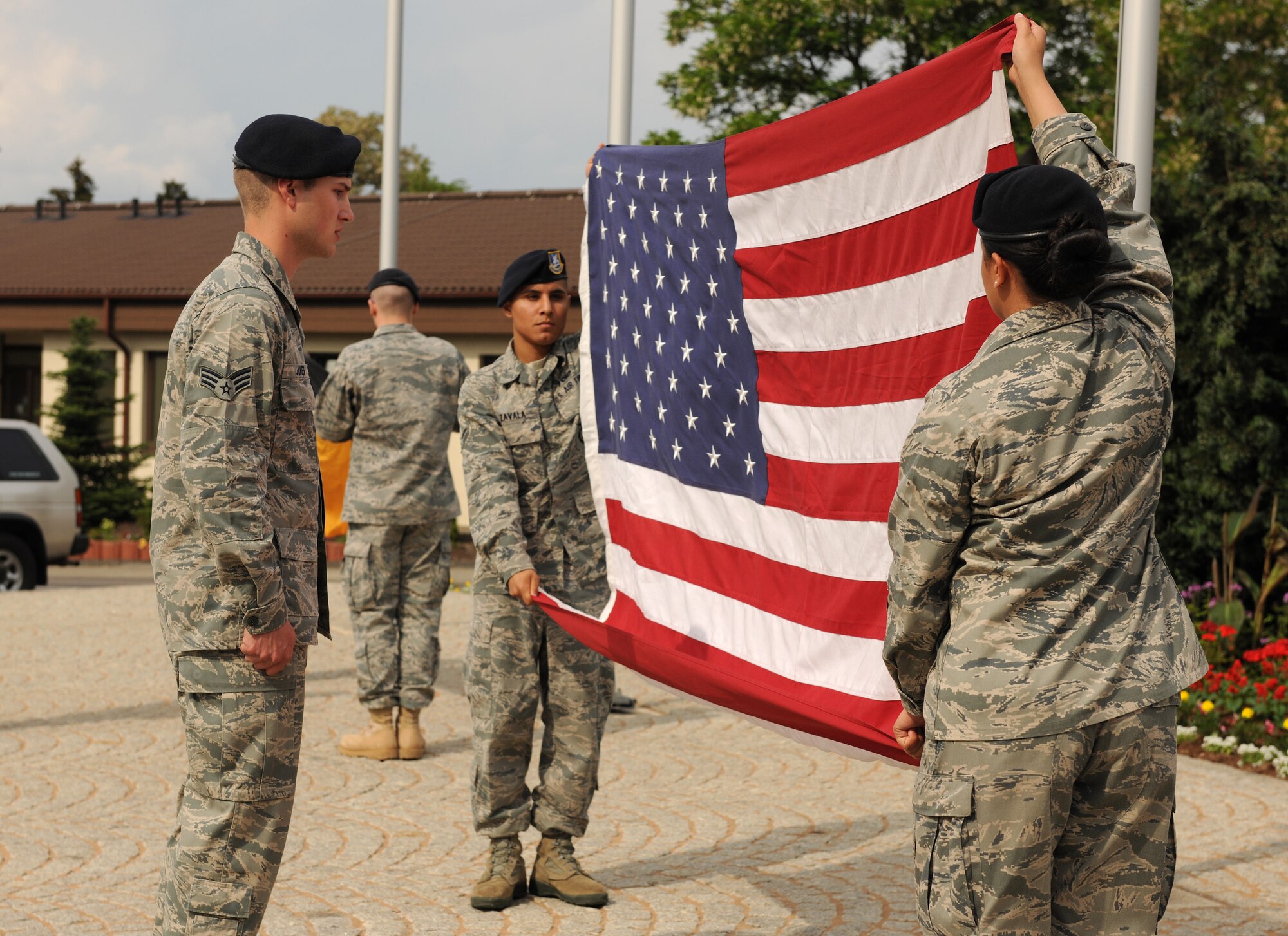 SPANGDAHLEM AIR BASE, Germany – Airmen from the 52nd Security Forces Squadron fold the German and U.S. flags during a retreat ceremony here May 20. The retreat ceremony coincided with National Police Week, which honors law enforcement members who have lost their lives in the line of duty for the safety and protection of others. (U.S. Air Force photo/Senior Airman Nathanael Callon)