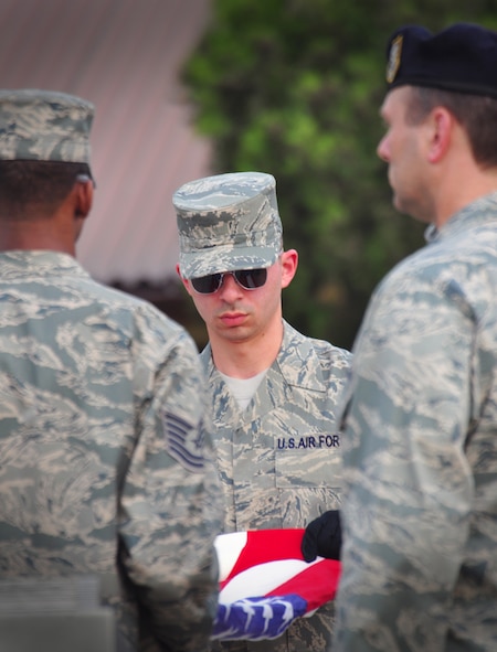 Osan Honor Guard members fold a flag during the ceremonial retreat May 19, honoring Master Sgt. Tara Brown from the Office of Special Investigations and Senior Airman Nicholas Alden from security forces for National Police Week. (U.S. Air Force photo/Staff Sgt. Chad Thompson)