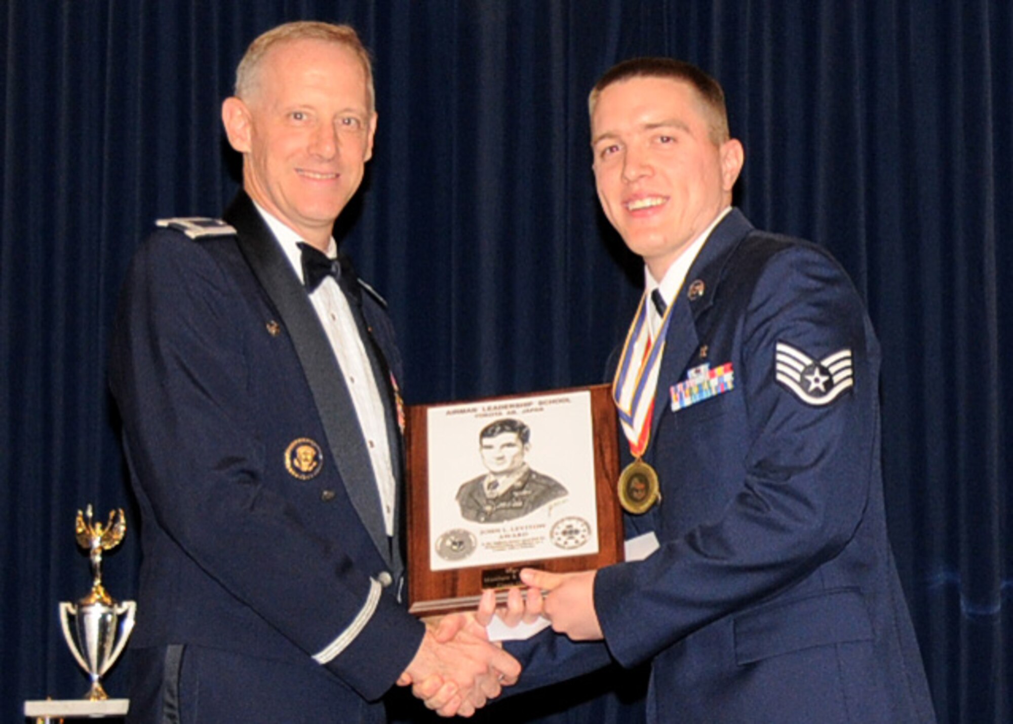 YOKOTA AIR BASE, Japan -- Colonel Otto Feather, 374th Airlift Wing commander, presents Staff Sgt. Matthew Shaffer, 374th Medical Support Squadron, the John L. Levitow Award, during the Airman Leadership School graduation ceremony at Yokota Air Base, Japan, May 19, Japan. (U.S. Air Force Photo/Senior Airman Andrea Salazar)