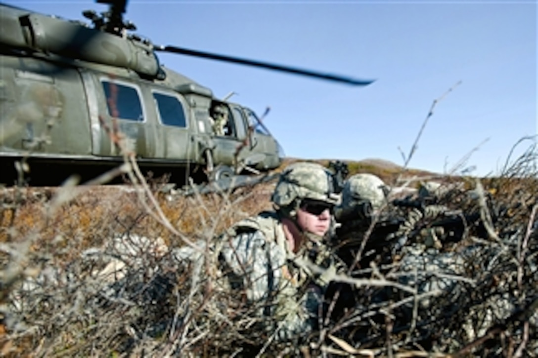 Army soldiers watch for the enemy while their UH-60 Black Hawk helicopter takes off during an air assault training exercise in Alaskaís Chugach Mountain Range on May 12, 2011.  The soldiers are assigned to Company C, 1st Battalion, 501st Infantry Regiment.  