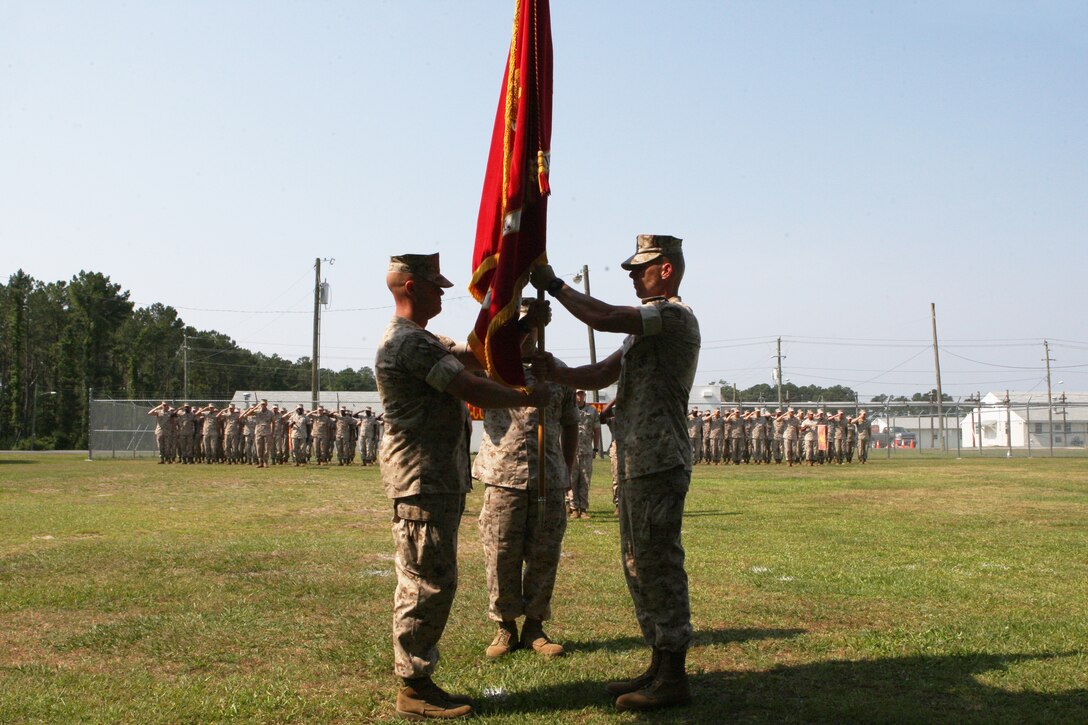 Sgt. Maj. Todd Parisi (right), outgoing director of the Staff Noncommissioned Officer Academy, passes the colors off to Sgt. Maj. Timothy Weber, incoming director, at the academy aboard Camp Johnson, May 24. Weber, who is coming from his recent billet as sergeant major of the 8th Communications Battalion, II Marine Expeditionary Force Headquarters Group, is replacing Parisi, who is to become the sergeant major for the 26th Marine Expeditionary Unit.