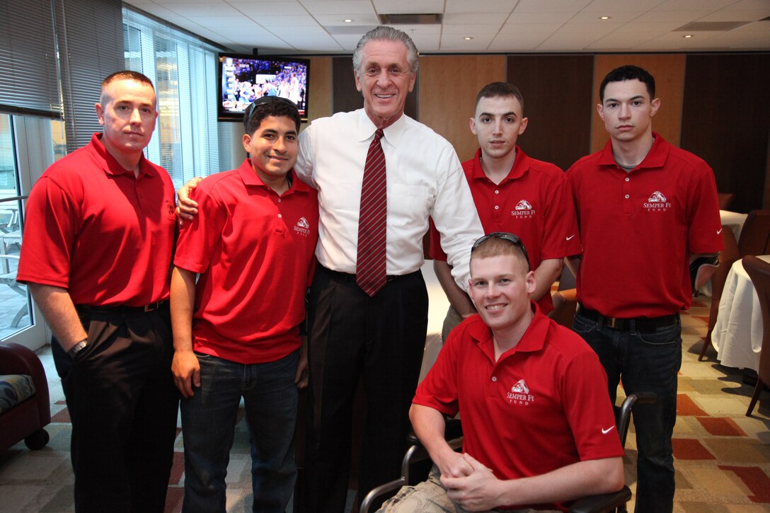 1st Sgt Michael Barrett, Cpl. Manuel Jiminez, Miami Heat President, Pat Riley, Sgt. Sean Belliston, Lcpl. Edward Lyons (in wheelchair) Cpl. Rory Hamill, pose for a picture in the Miami Heat Family room before being honored for their service during the playoff match between the Miami Heat and Chicago Bulls, May 24. Earlier that day, these Marines visited both the U.S. Southern Command Headquarters and U.S. Marine Corps Forces, South Headquarters where they were welcomed and given a tour of both commands. (Photo courtesy of the Miami Heat)
