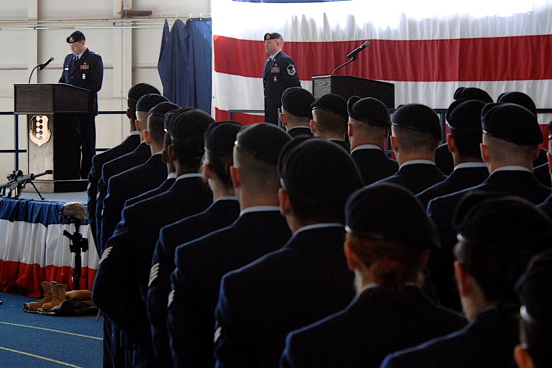 Airmen from the 28th Security Forces Squadron stand at parade rest while Maj. Steven Ohlmeyer, 28th SFS commander, recounts the significance of National Police Week 2011 during a remembrance ceremony in the Pride Hangar on Ellsworth Air Force Base, S.D., May 20, 2011. The names of all the law enforcement members killed in the line of duty between May 2010 and May 2011 were read during the ceremony. (U.S. Air Force photo by Master Sgt. Michael Morford)