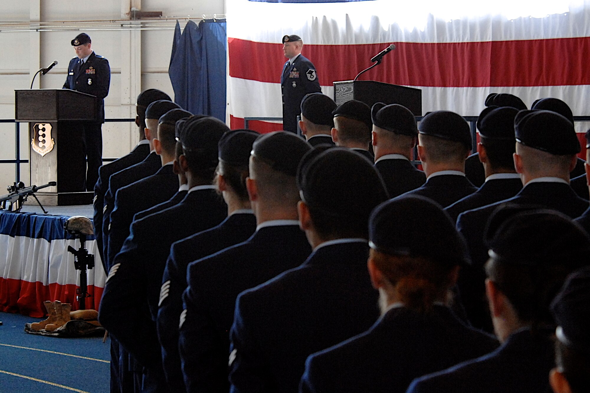 Airmen from the 28th Security Forces Squadron stand at parade rest while Maj. Steven Ohlmeyer, 28th SFS commander, recounts the significance of National Police Week 2011 during a remembrance ceremony in the Pride Hangar on Ellsworth Air Force Base, S.D., May 20, 2011. The names of all the law enforcement members killed in the line of duty between May 2010 and May 2011 were read during the ceremony. (U.S. Air Force photo by Master Sgt. Michael Morford)