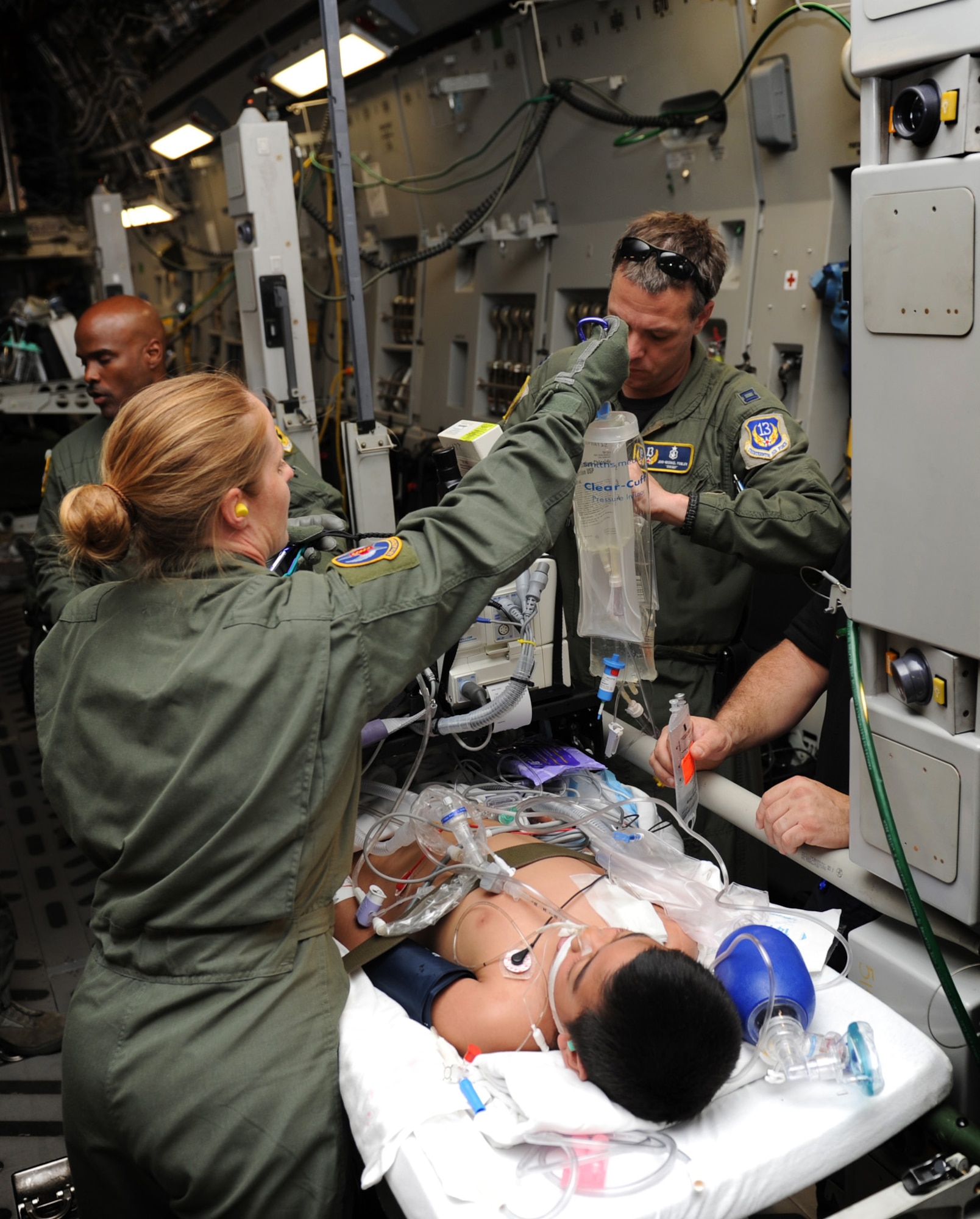 Master Sgt. Molly Quentin and Capt. John-Michael Fowler care for a critically ill patient on a medical evacuation mission May 22, 2011, from Pago Pago, American Samoa, to Tripler Army Medical Center, Hawaii. Sergeant Quentin is an aeromedical evacuation technician assigned to the 18th Aeromedical Evacuation Squadron Det. 1. Captain Fowler is a critical care air transport nurse with the 13th Air Force surgeon general's office. (U.S. Air Force photo/Senior Airman Lauren Main)