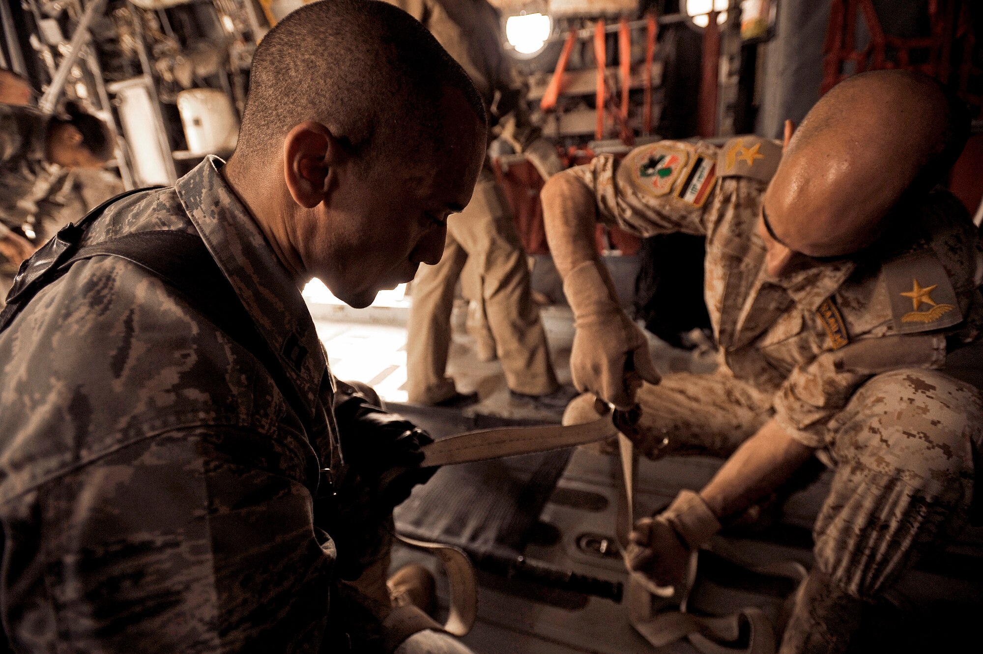 Capt. Reggie Brown (left) teaches his Iraqi counterparts how to secure a litter to the floor of a C-130 Hercules May 19, 2011. Six Iraqi medics learned the basics of aeromedical evacuation over two days with Air Force and Army advisers from Sather Air Base, Joint Base Balad and Camp Taji. The medics also learned about medical evacuation capabilities and safety considerations for UH-60 Blackhawk, Mi-171 Hip and UH-1 Huey helicopters. Captain Brown is deployed from Eglin Air Force Base, Fla., and hails from Long Island, N.Y. Captain Brown is a 332nd Expeditionary Medical Group critical care nurse. (U.S. Air Force/Tech. Sgt. Jason Lake)