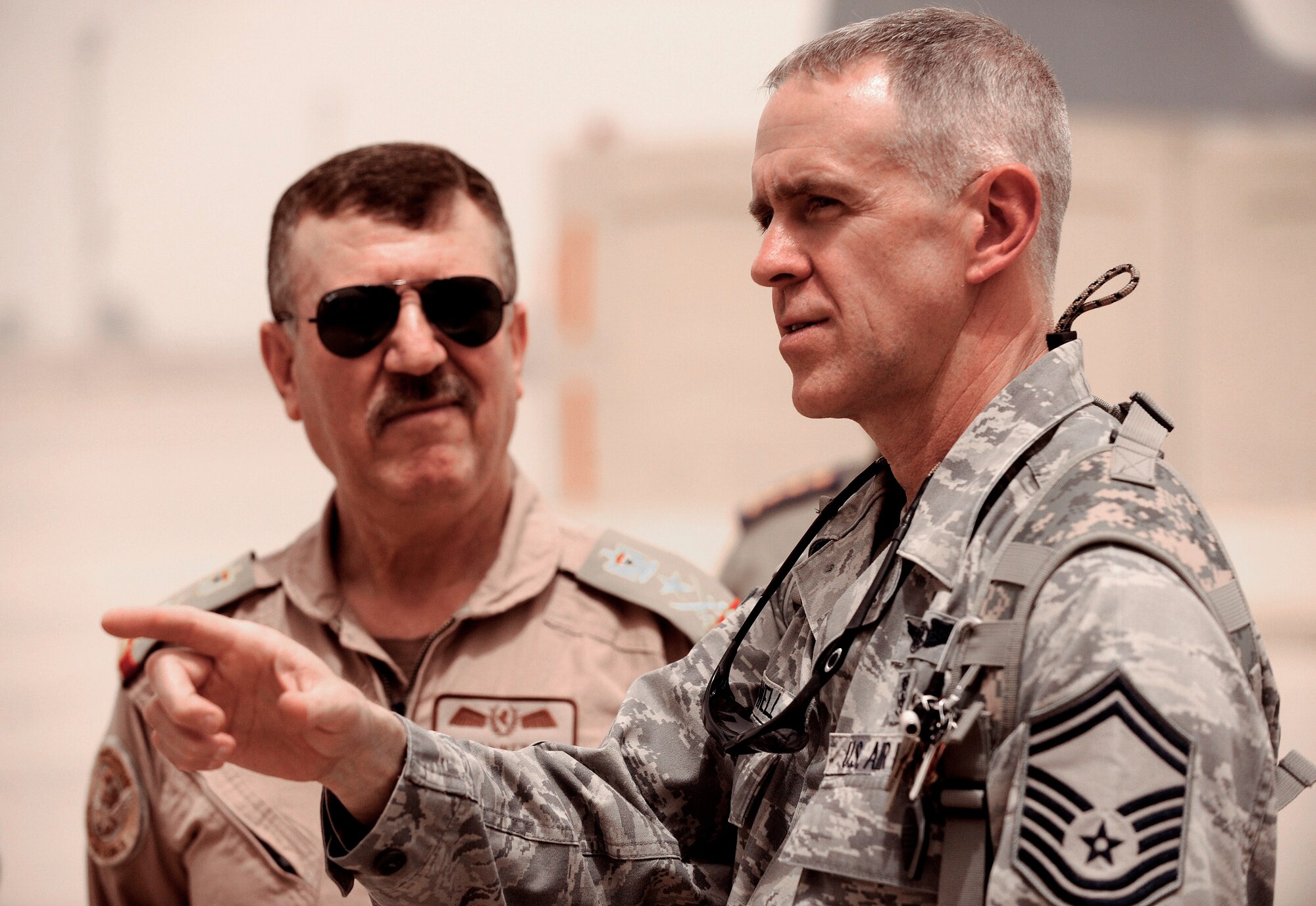 Senior Master Sgt. Marvin Howell speaks with Iraqi air force Chief of Staff Lt. Gen. Anwar Ahmed as Iraqi medics practice litter carrying commands May 19, 2011. Six Iraqi air force medics received two days of joint aeromedical evacuation training with Air Force and Army advisers. Sergeant Howell is the 332nd Expeditionary Medical Operations Squadron superintendent. (U.S. Air Force/Tech. Sgt. Jason Lake)