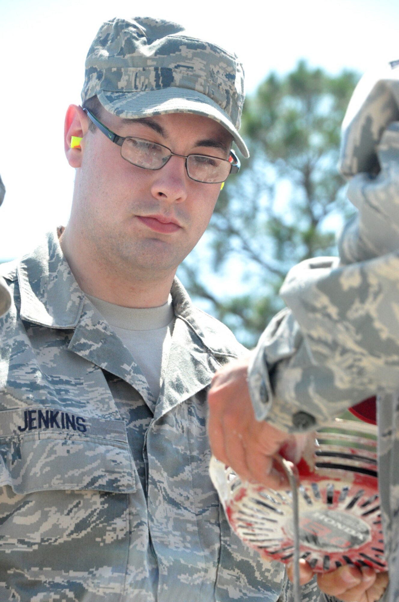 U.S. Air Force Senior Airman Ben Jenkins from the 446th Civil Engineer Squadron helps re-spool a broken pull cord on an asphalt grinding machine during a field exercise at Tyndall Air Force Base, Fla. on March 23, 2011. Airman Jenkins is one of 30 Reservists from the 446th CES participating in Silver Flag 2011, a training exercise designed to improve the readiness capability of Air Force civil engineers. Airman Jenkins is a heavy construction equipment operator with the 446th CES. The Tillamook, Ore. native is an applied sciences student at Portland Community College in his civilian life. (U.S. Air Force photo by Staff Sgt. Grant Saylor/Released)
