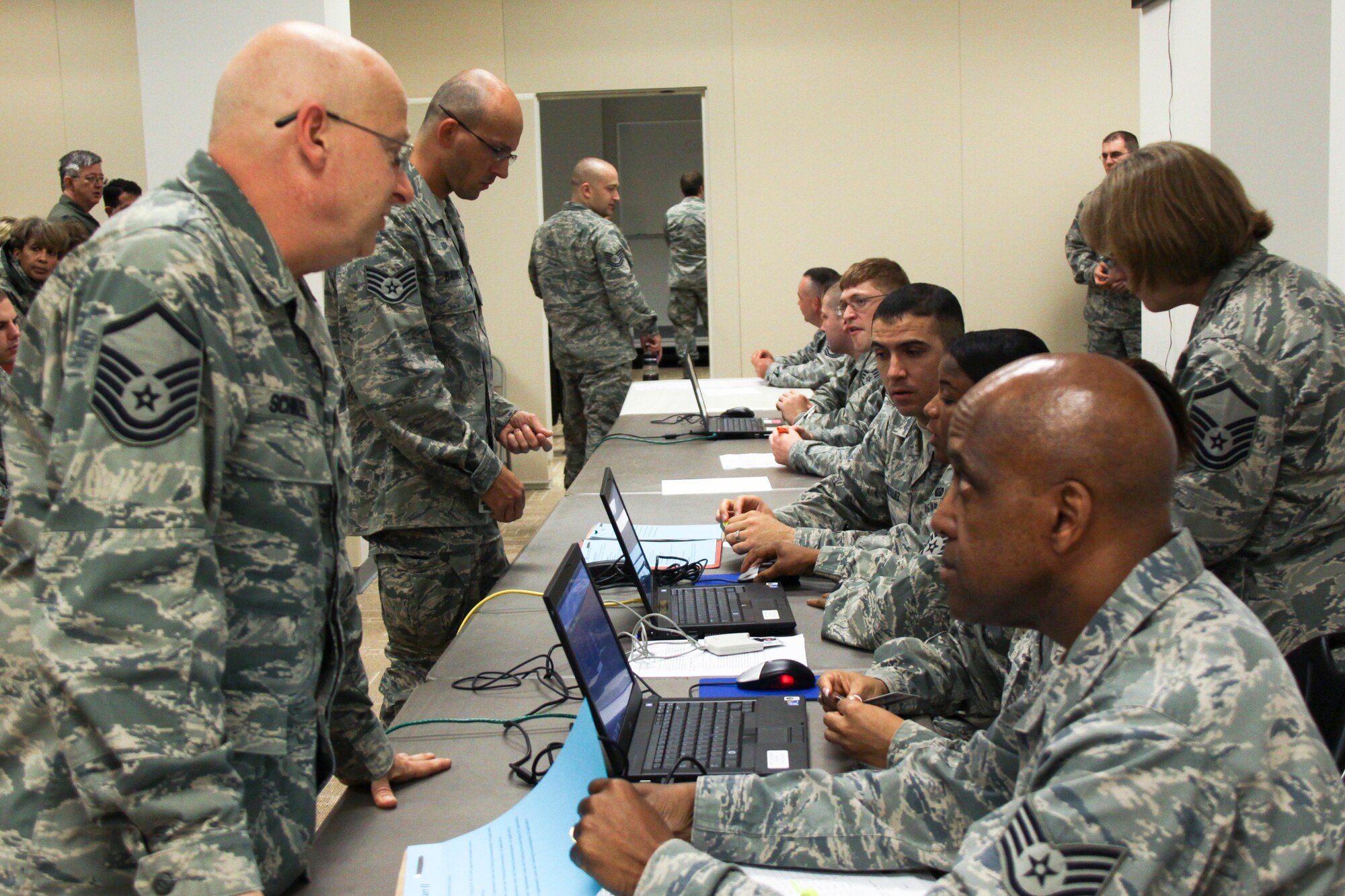 Tech. Sgt. Myron McNair inspects Master Sgt. Mark Schinzel's mobility folder during the mobility processing portion of the pre-deployment exercise here, May 15, 2011. (U.S. Air Force photo by SrA Melissa Knox)