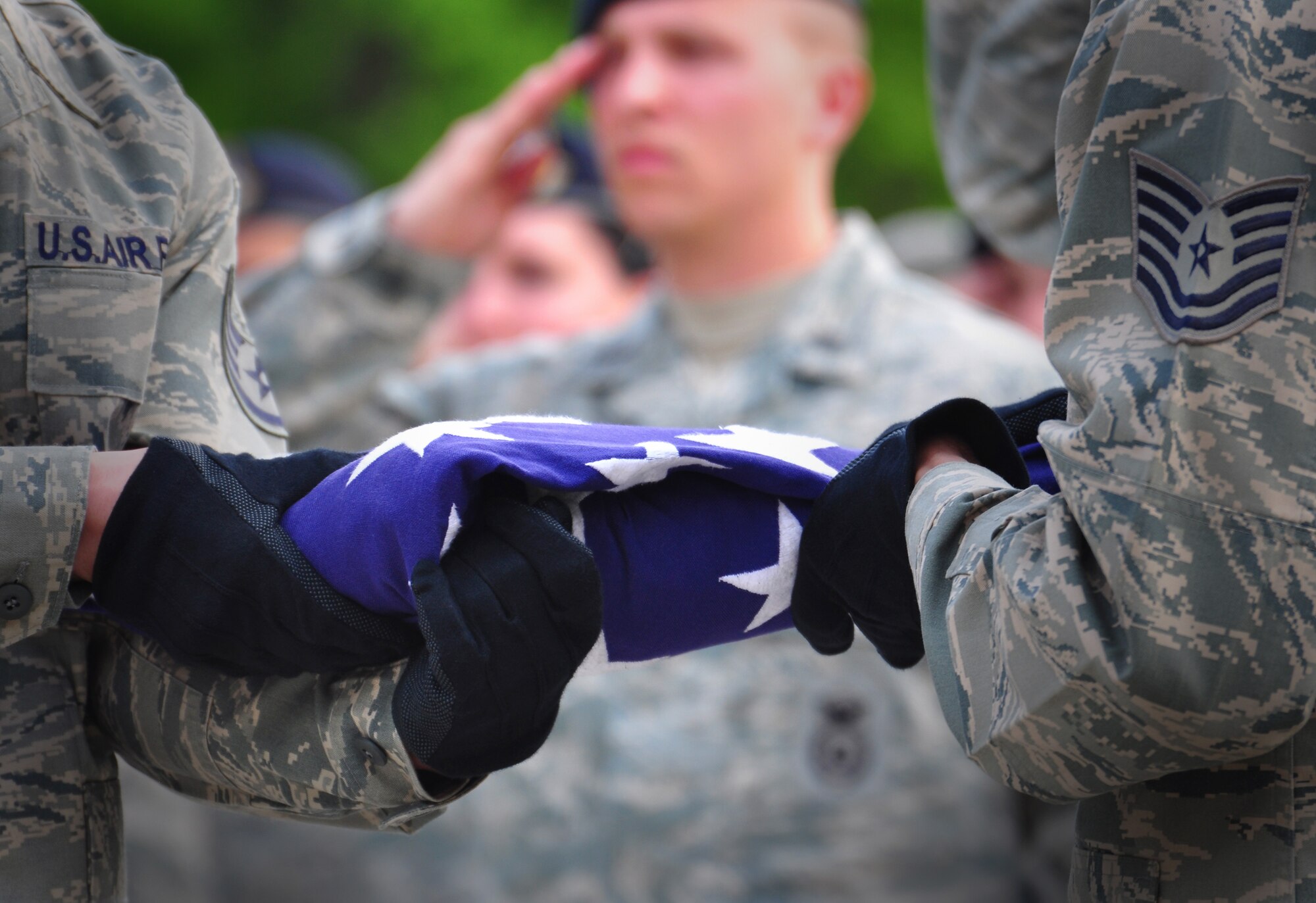 Osan Air Base Honor Guard members fold a flag during the ceremonial retreat May 19, honoring Master Sgt. Tara Brown from the Air Force Office of Special Investigations and Senior Airman Nicholas Alden from security forces for National Police Week. (U.S. Air Force photo by Staff Sgt. Chad Thompson)