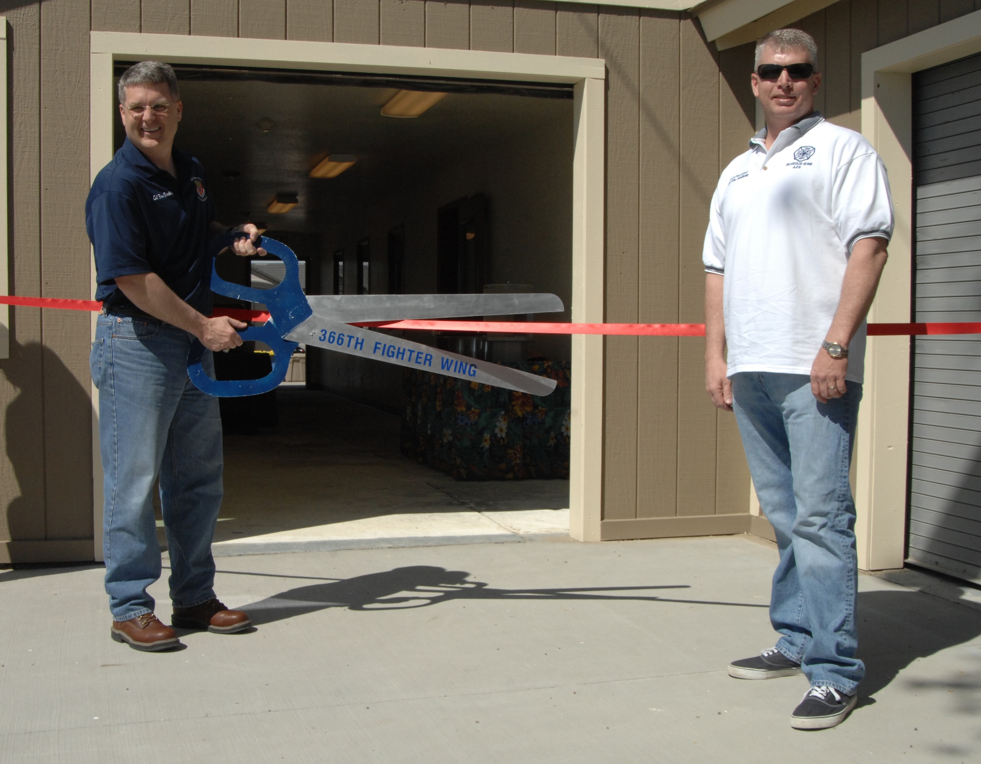 MOUNTAIN HOME AIR FORCE BASE, Idaho – Colonel Ron D. Buckley, 366th Fighter Wing Commander, cuts the ceremonial ribbon May 21, officially opening the main building of the Strike Dam Marina while Lt. Col. Michal D. Holliday, 366th Civil Engineering Squadron commander, looks on. Personnel from the 366th CES used rebuilding Strike Dam Marina’s main building as a training opportunity. (U.S. Air Force photo by Senior Airman Benjamin Sutton.)