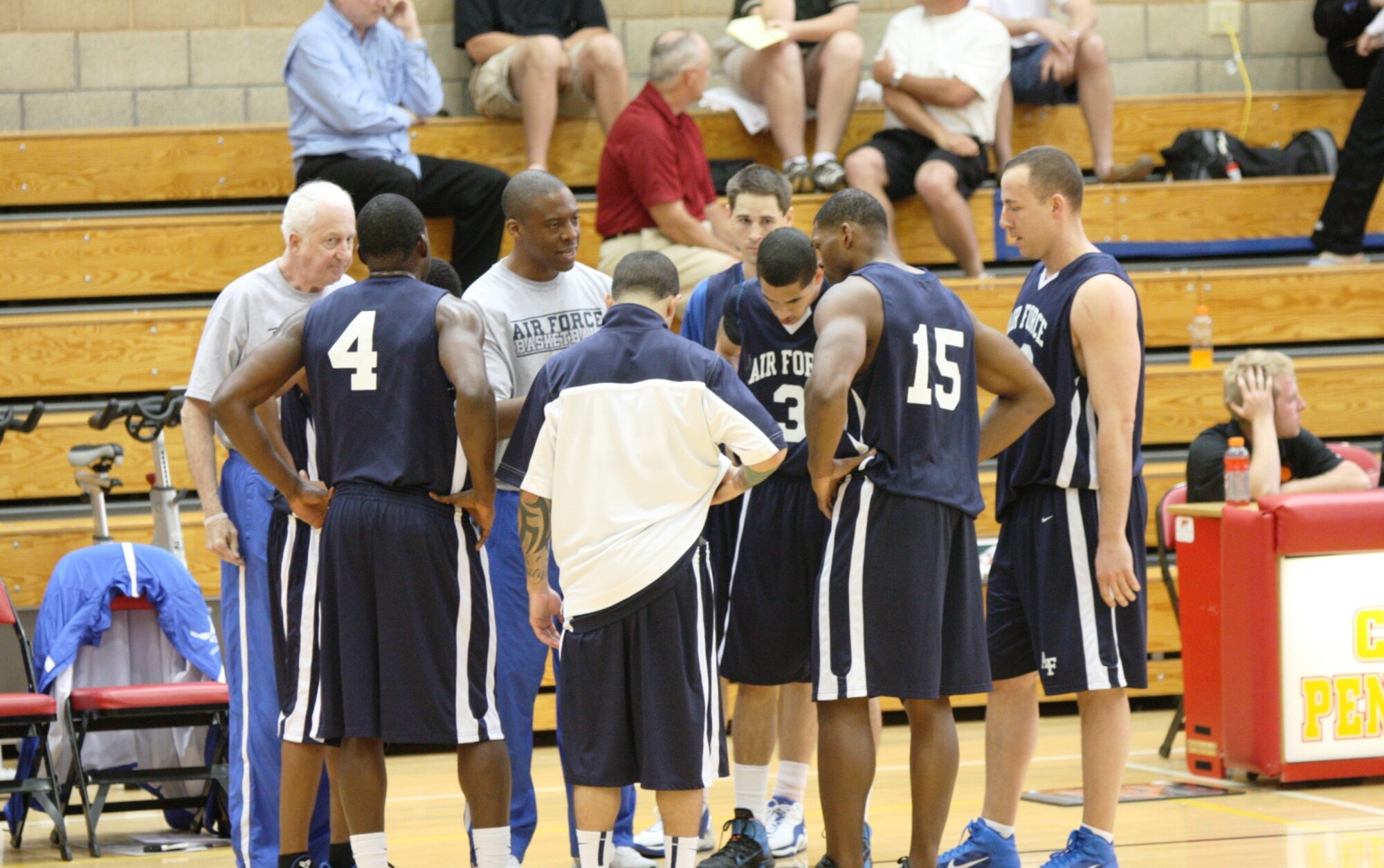The Air Force men's basketball team receives a pep talk from Men's Coach Tyron Wright of the U.S. Air Force Academy during the Armed Forces basketball tournament. The men's team won their sixth consecutive championship when they defeated the Army 71-65. (Courtesy photo)