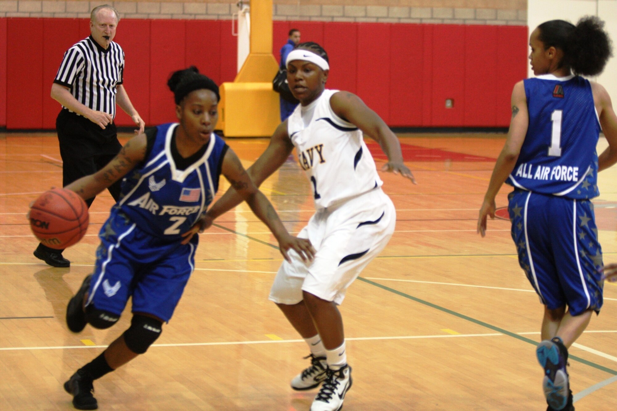 Senior Airman Javita Cotton, Spangdahlem Air Base, Germany, zips past a Navy defender during the Armed Forces basketball tournament April 10-18 at Camp Pendleton, Calif. The Air Force women won the championship title by defeating the Army's women team 67-51. The women's championship marked the first time both the Air Force men and women's team won a title during the same year. (Courtesy photo)